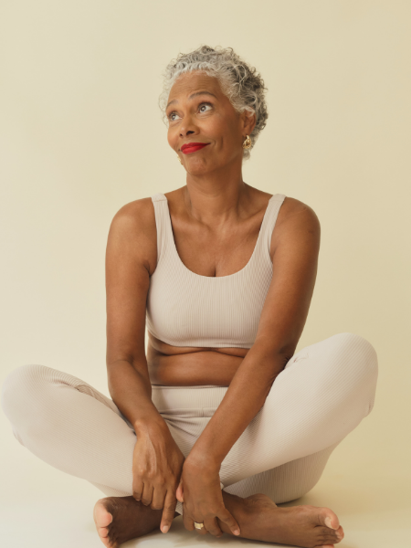 grey haired black woman in yoga clothes and position