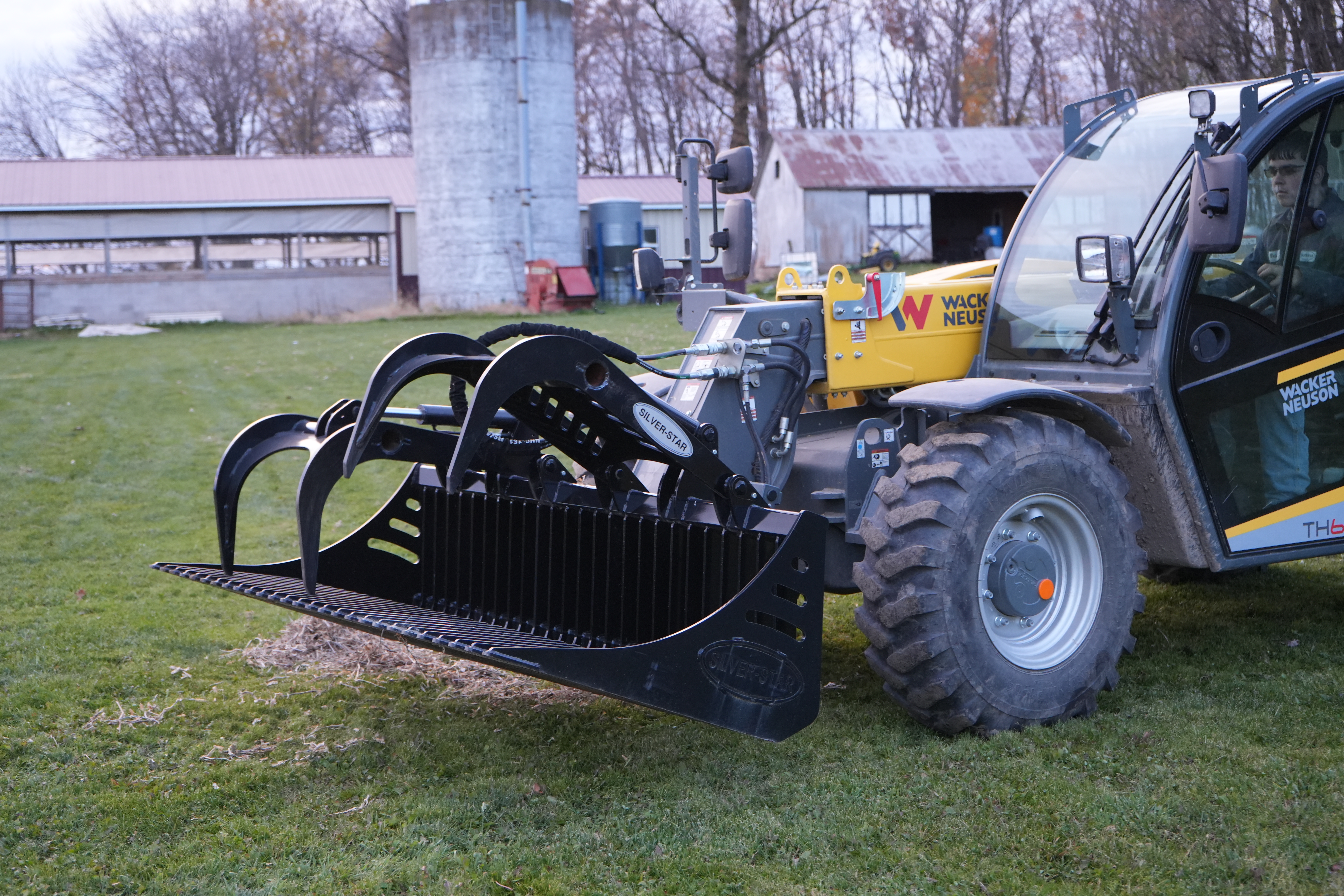Heavy-duty rock bucket on skid steer ready for tough digging in rocky ground Heavy-duty rock bucket on skid steer ready for tough digging in rocky ground