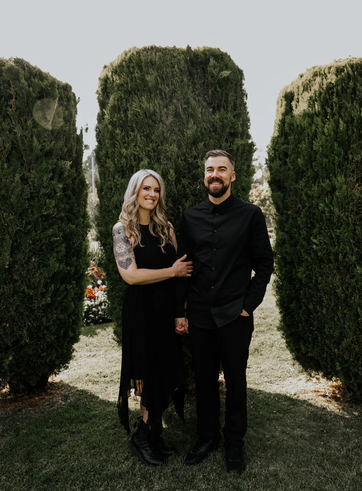 Cori and Jake Sartori, SLC Life Coaching life coaches, standing together in a garden