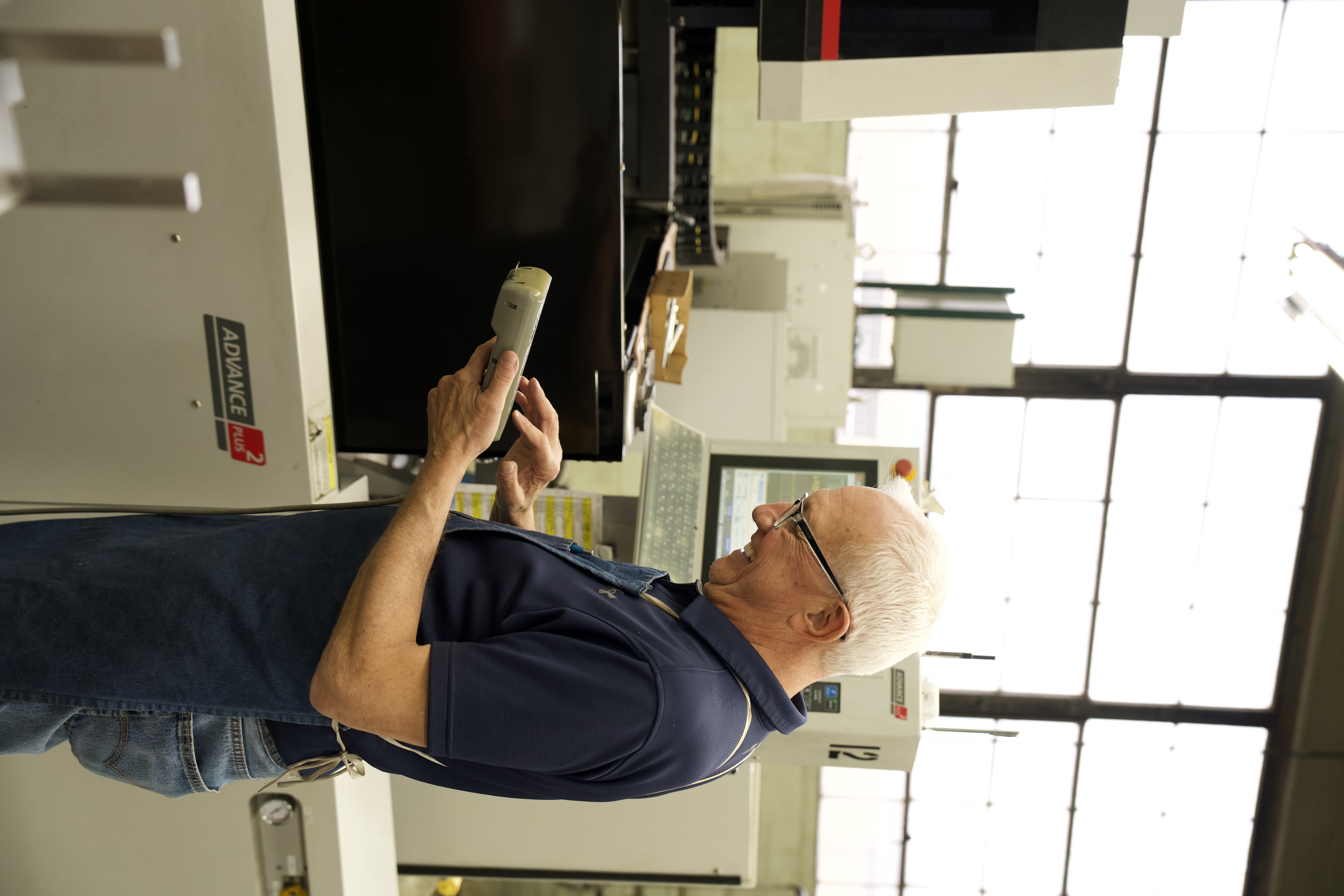 Operator inspecting a stamped part at Manor Tool