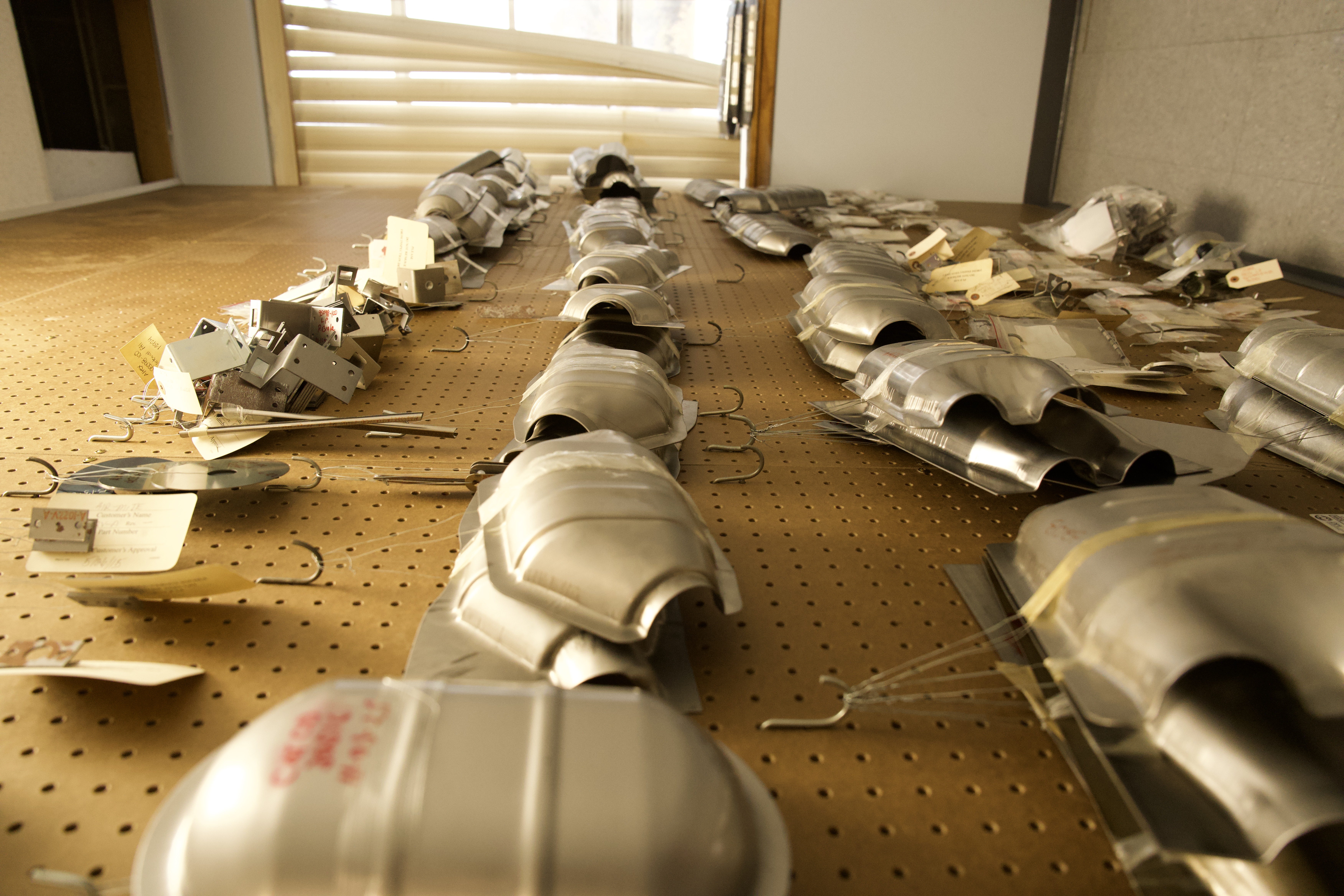 Precision stamped metal components laid out for quality inspection at Manor Tool