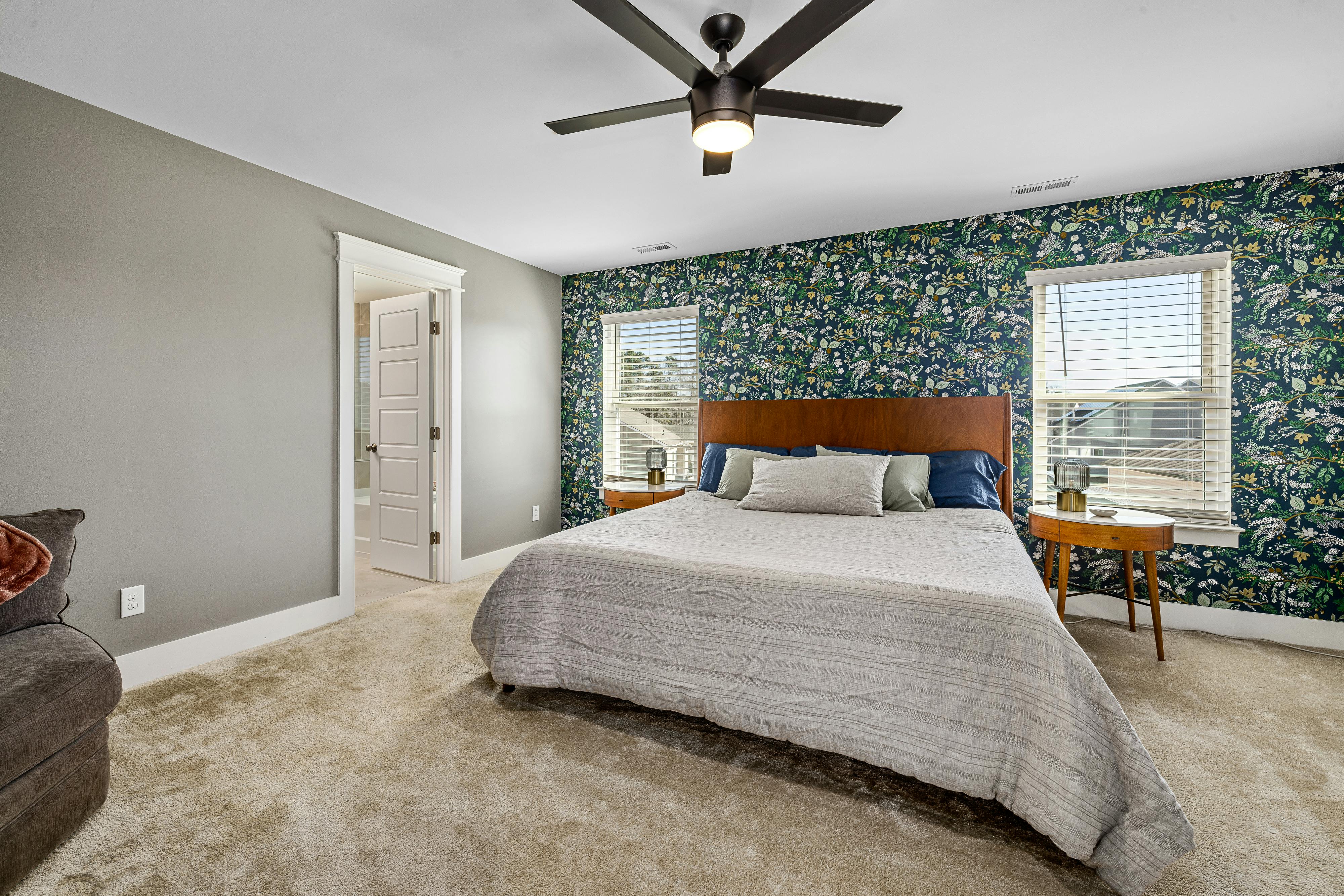 Botanical floral wallpaper accent wall behind a bed in a modern Cleveland bedroom