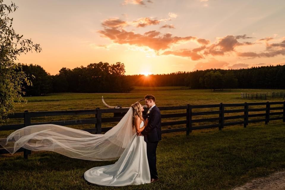 A couple at sunset by the fence line