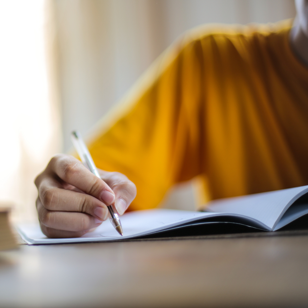 image of student writing on paper