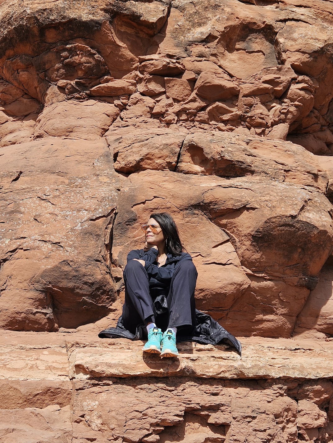 Darieth Chisolm seated in quiet reflection among the red rocks of Sedona