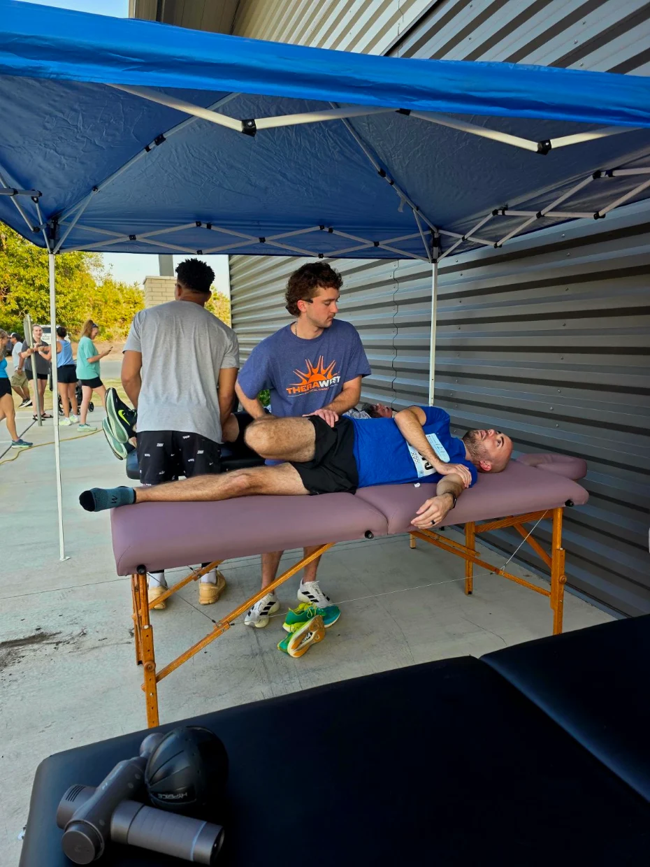 a TheraWest therapist helping people stretch at a community event a TheraWest therapist helping people stretch at a community event