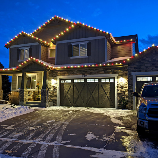 Professional Christmas light installation in Fort Collins featuring warm white and red commercial-grade C9 bulbs on residential home exterior