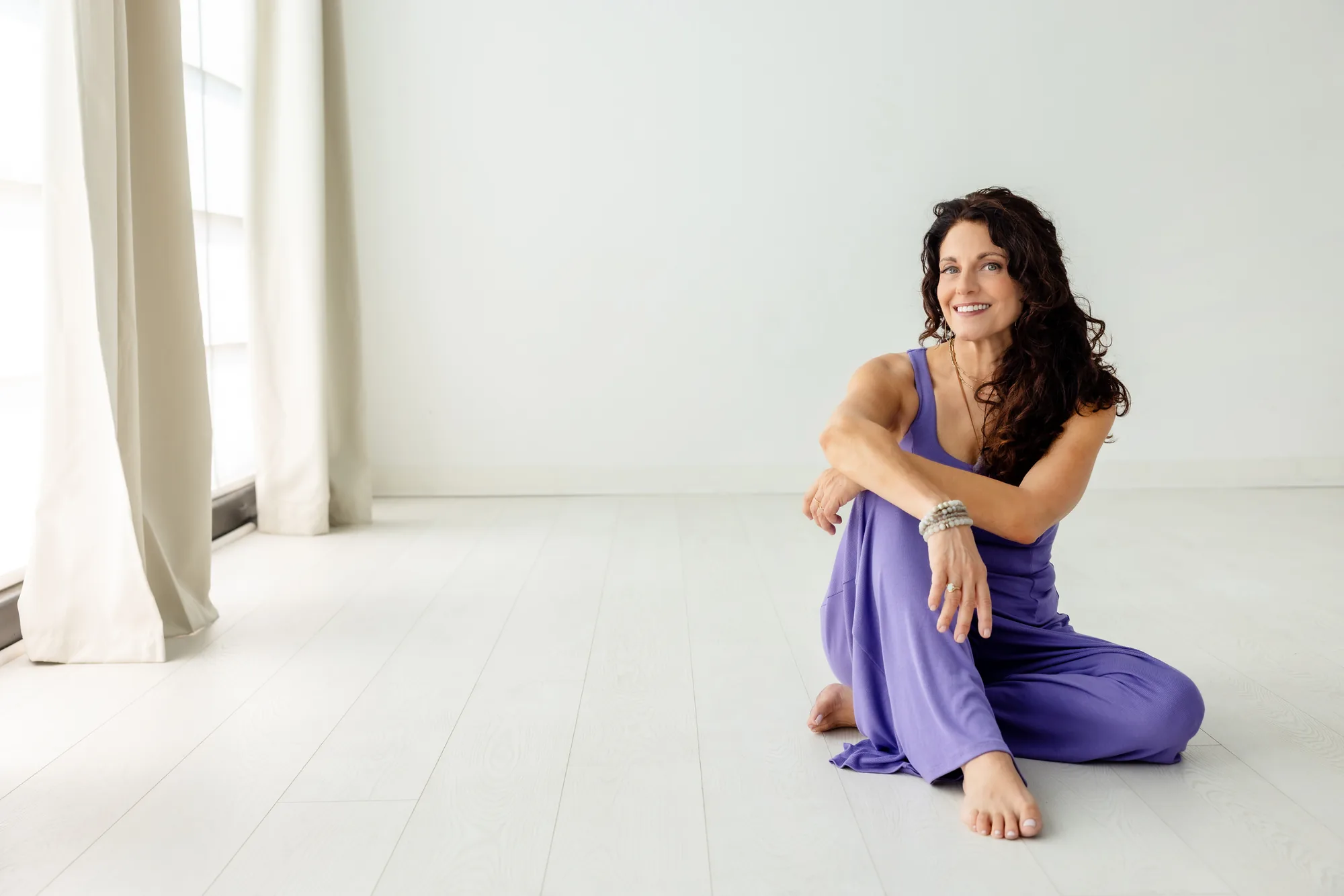 Kristina seated on the studio floor, smiling