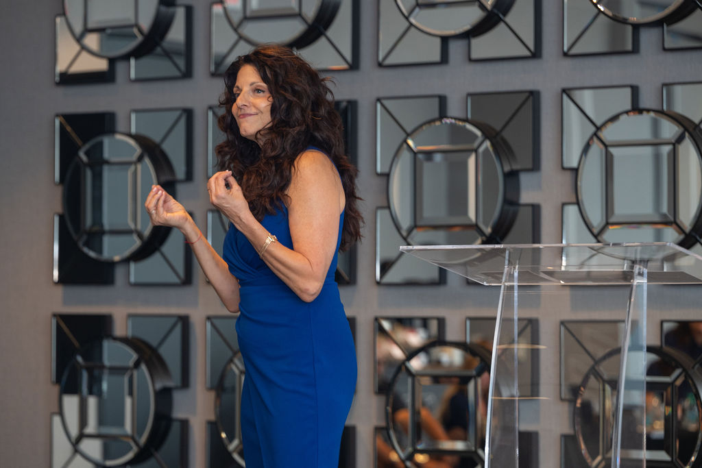Kristina Shafton speaking on stage at a live event