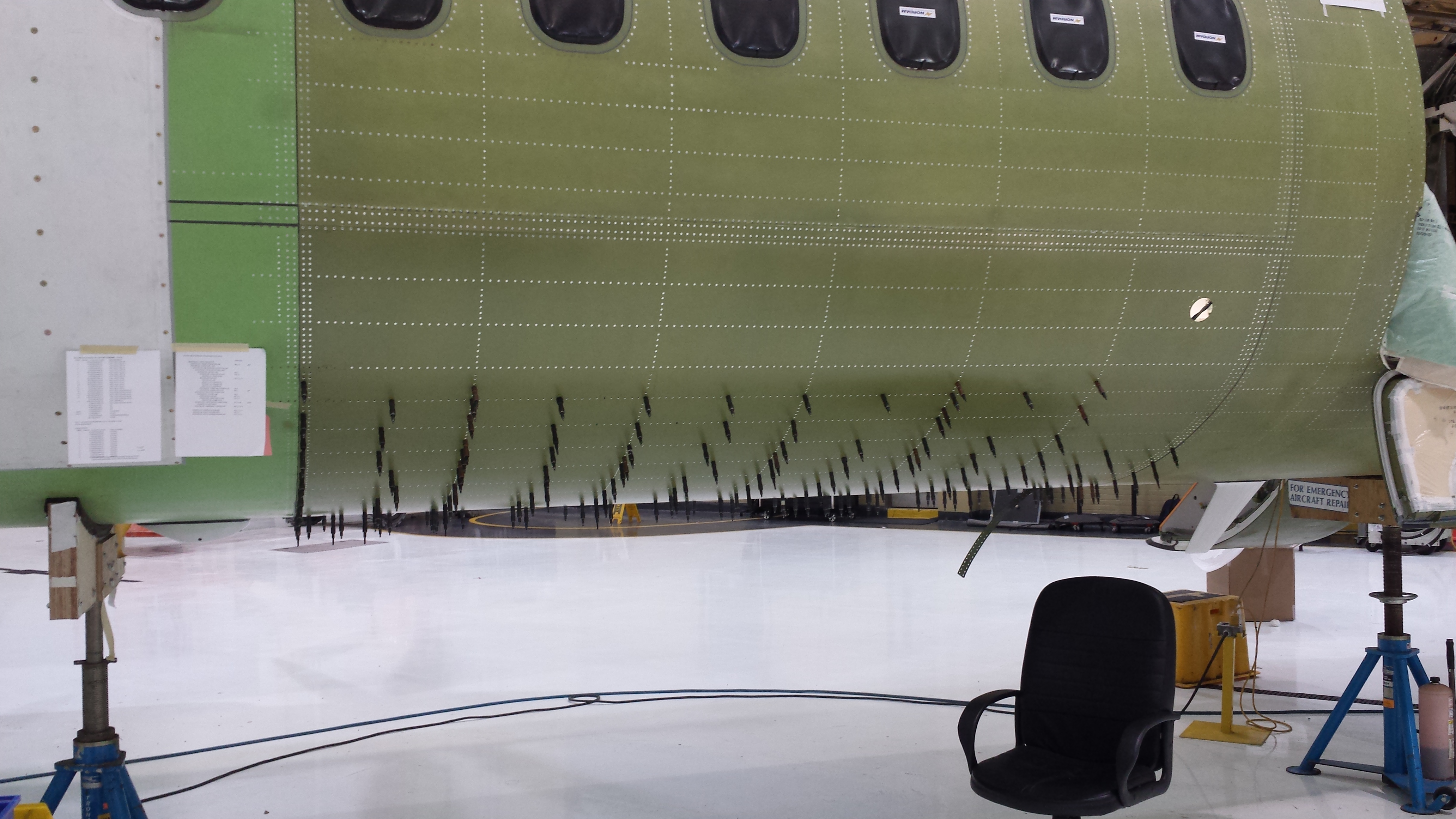 Engineers examining aircraft external panels.