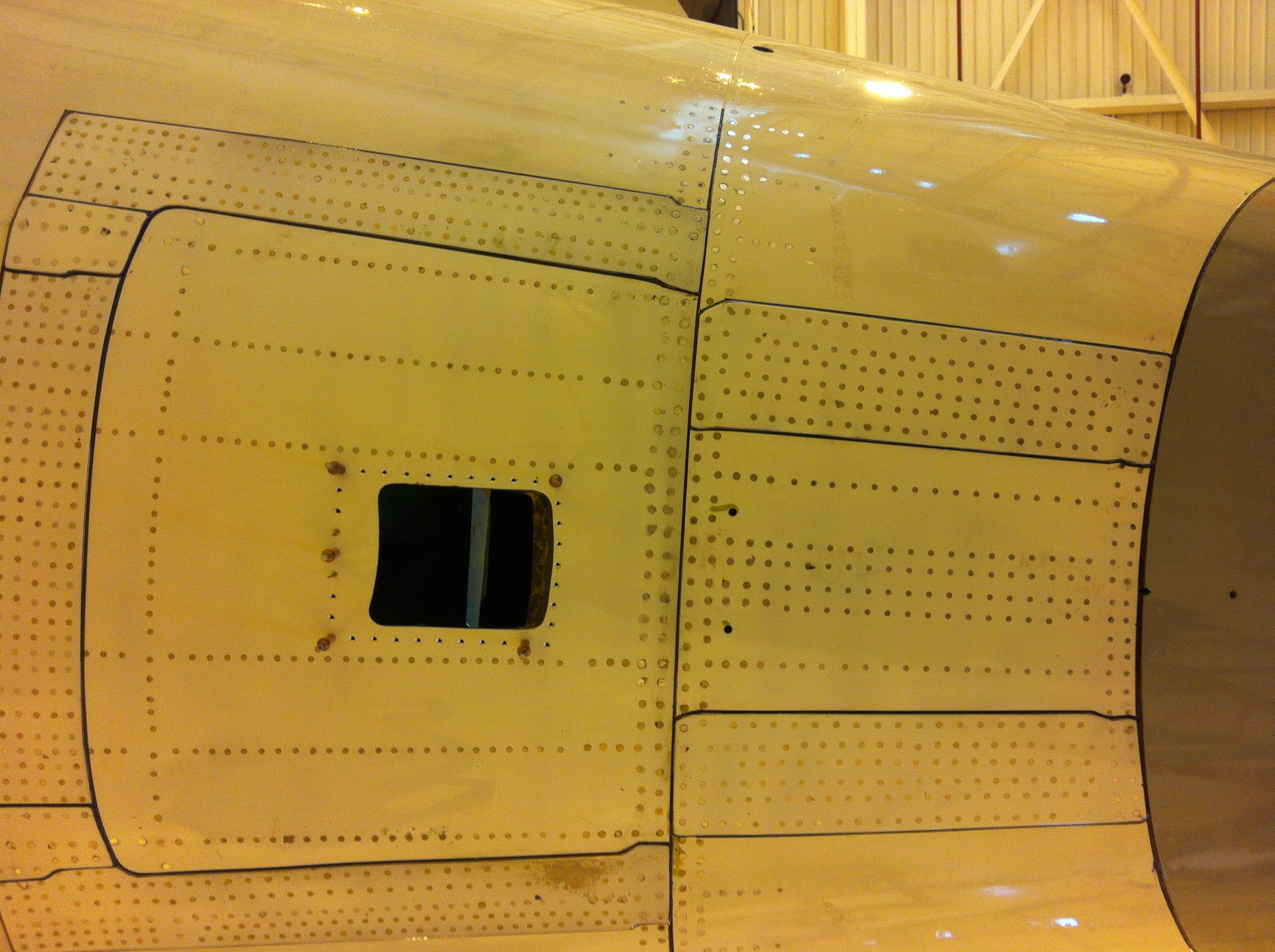 Engineers examining aircraft external panels.