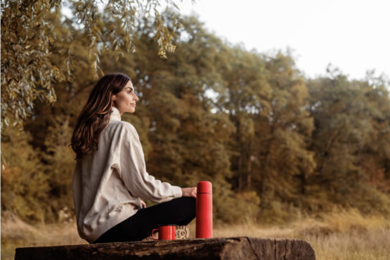 Woman sitting quietly in a peaceful woodland setting