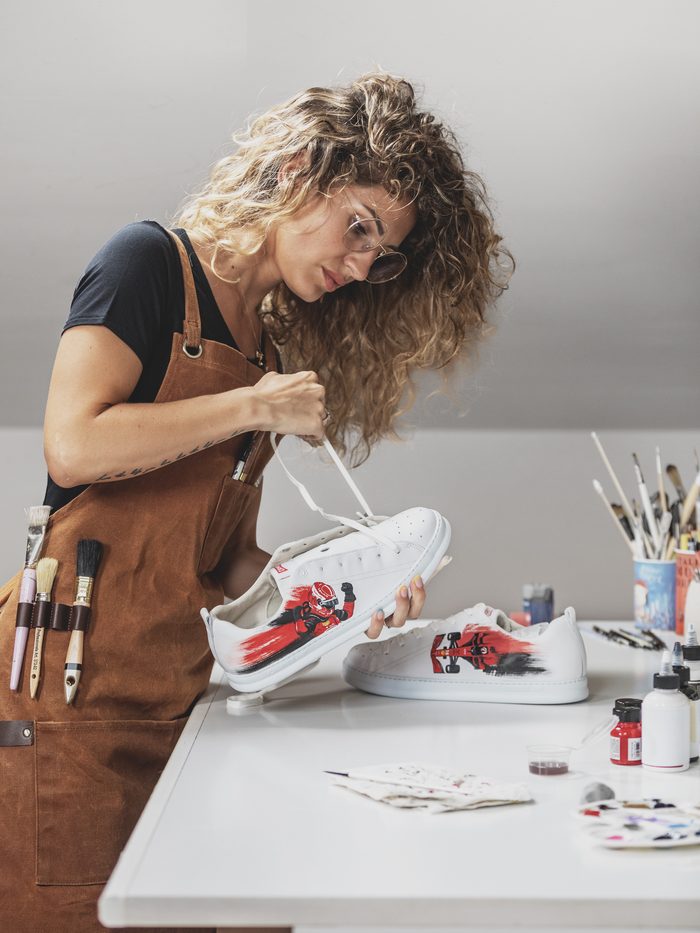Jessica dipinge una sneaker nel suo atelier