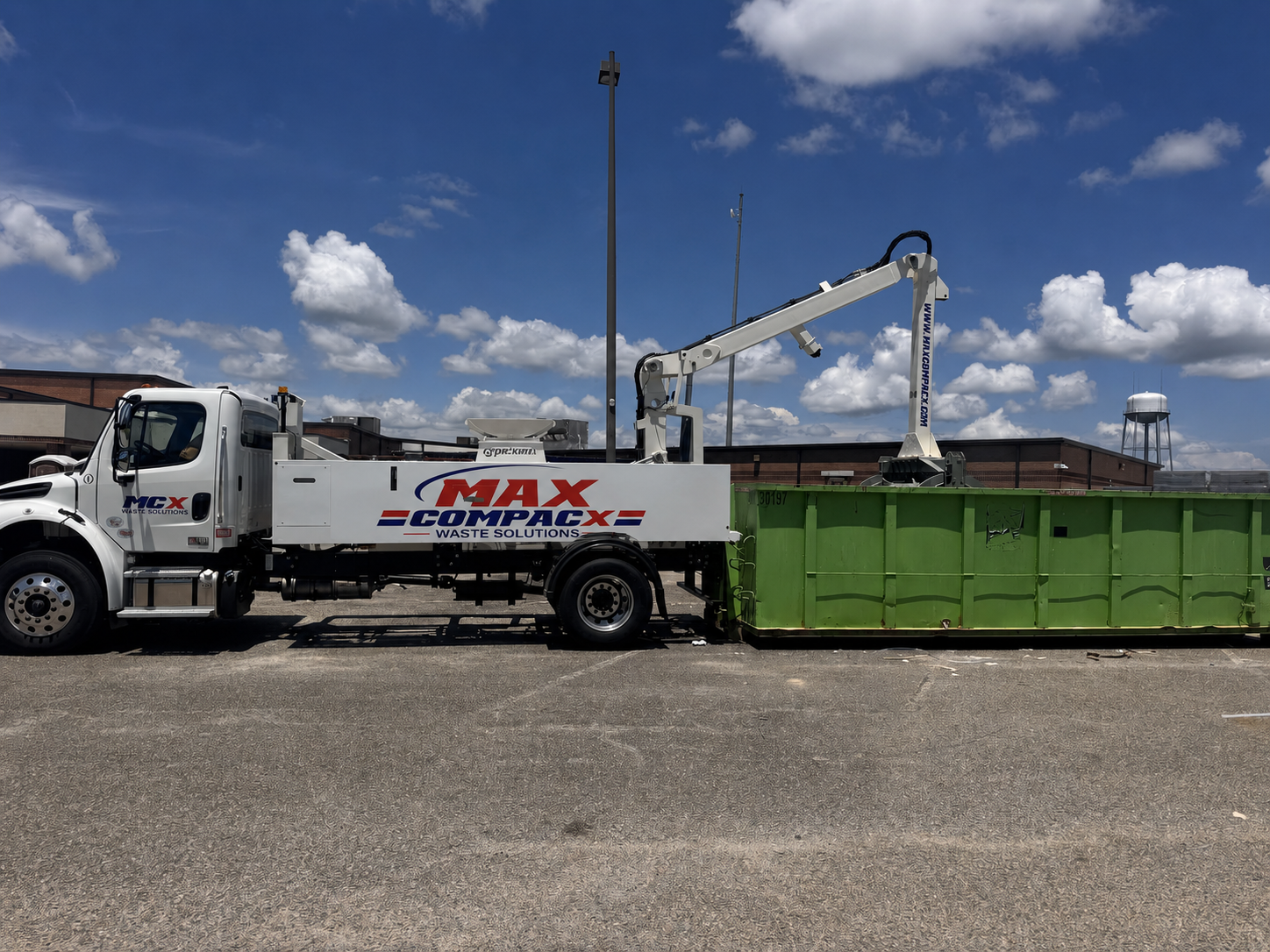 Compaction drum pressing a packaging-heavy load inside a roll-off container in West Macon