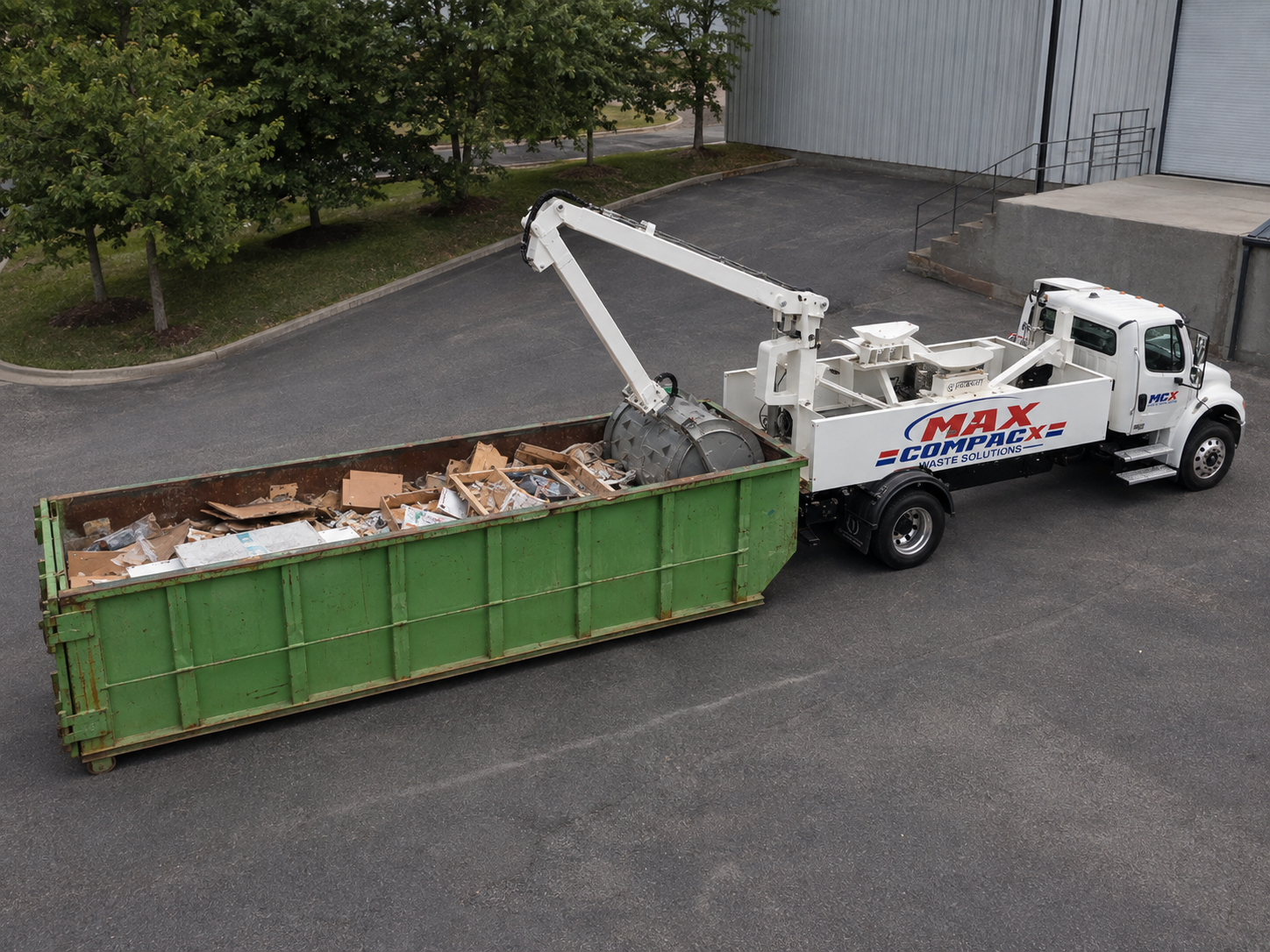 Roll-off container placed at the service side of a shopping plaza in North Macon
