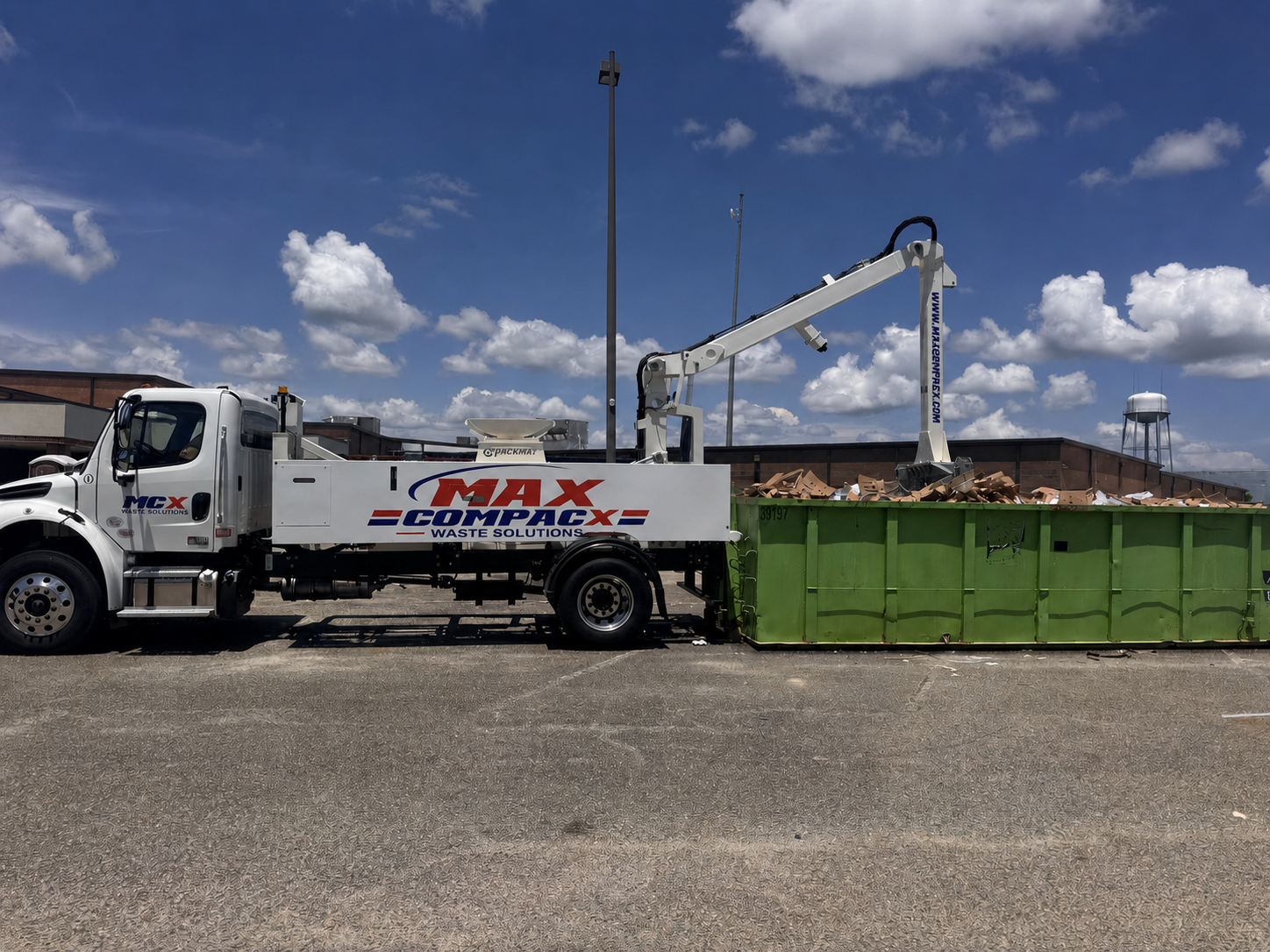 A roll-off container placed on a wide gravel area at a west-county commercial property