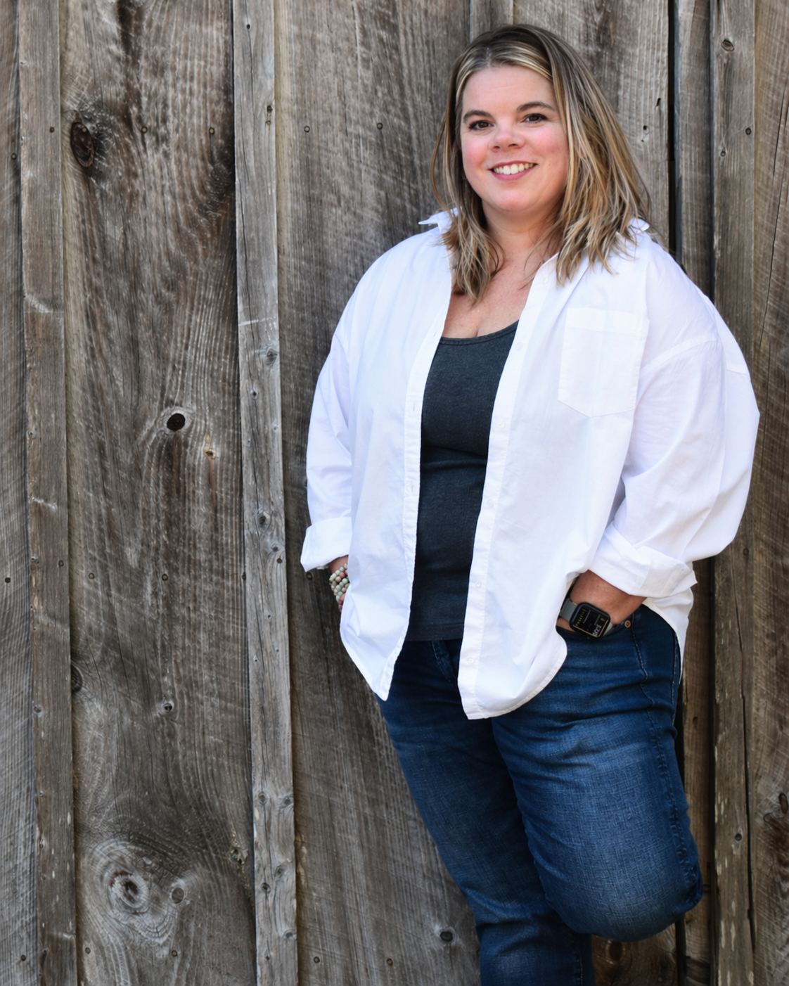 Pam Godbois leaning against a wood wall