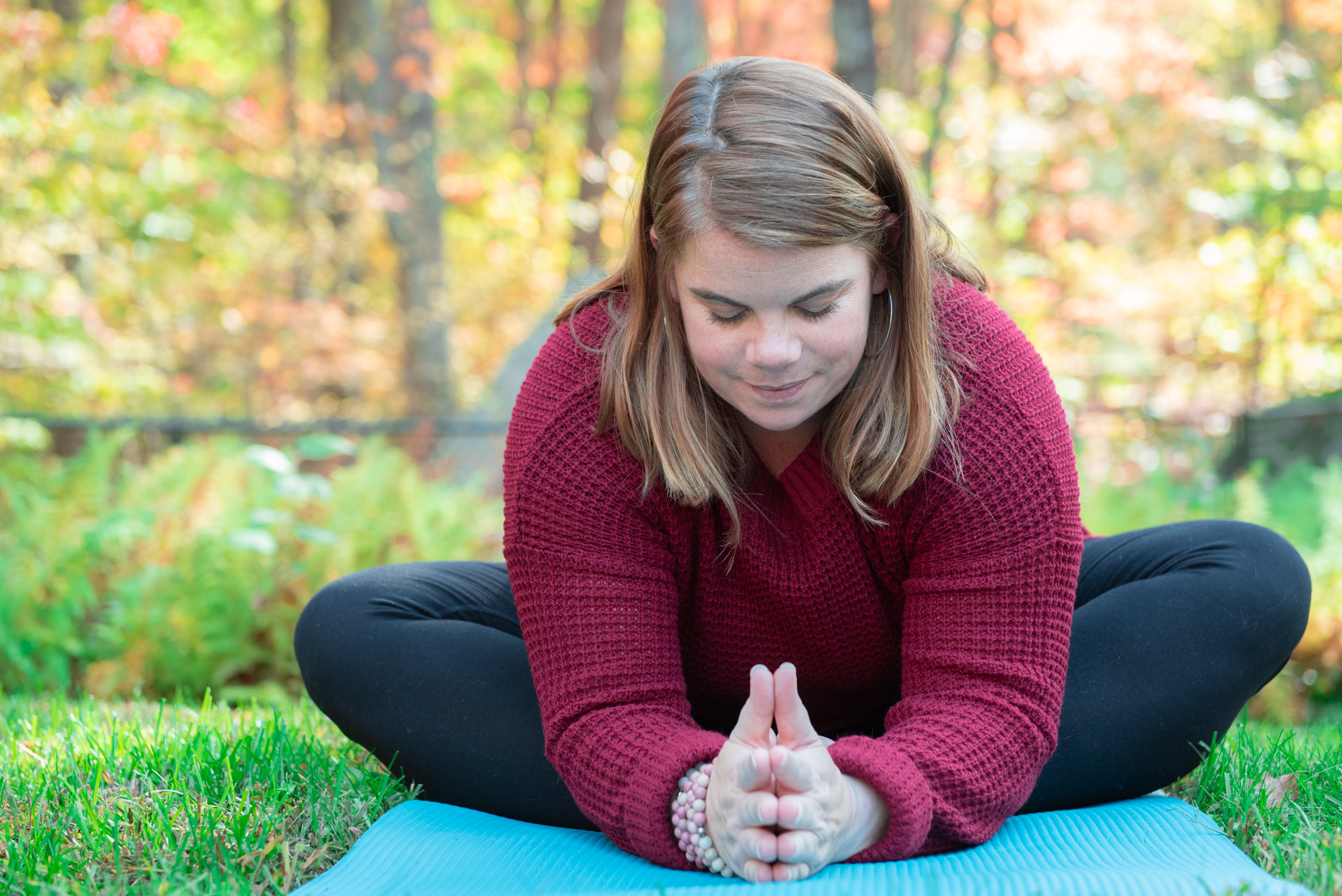 Pam Godbois practicing yoga outdoors in autumn