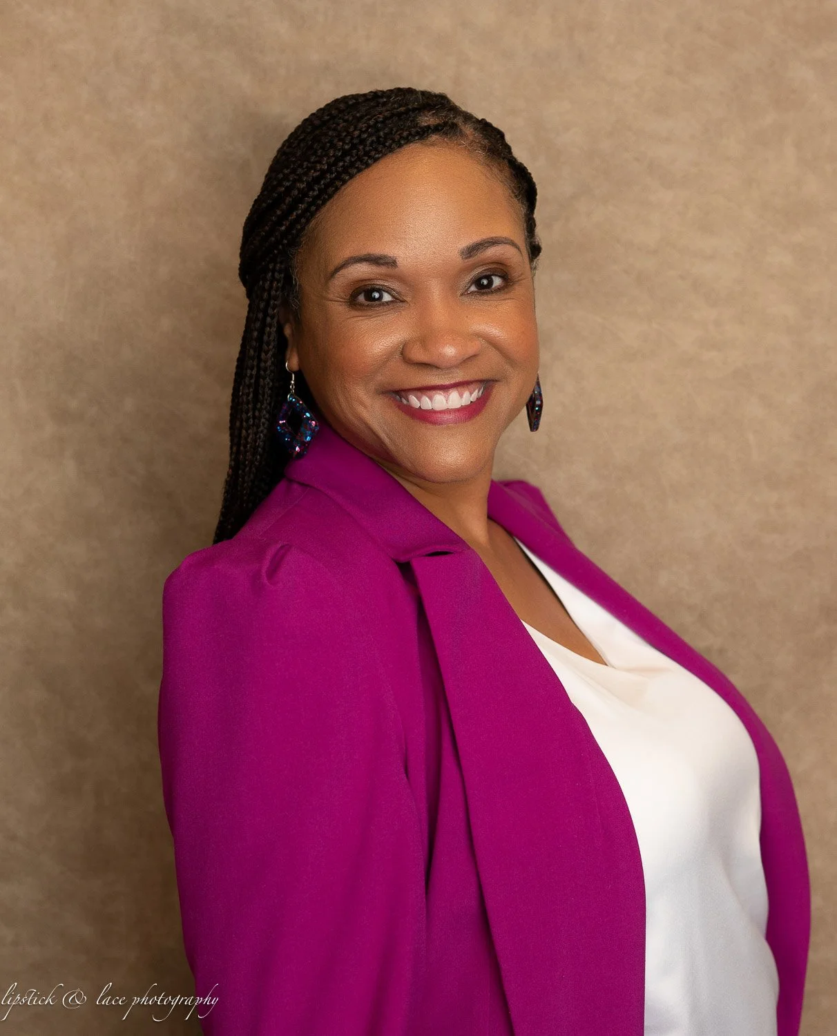 Smiling woman in magenta blazer with braided hair