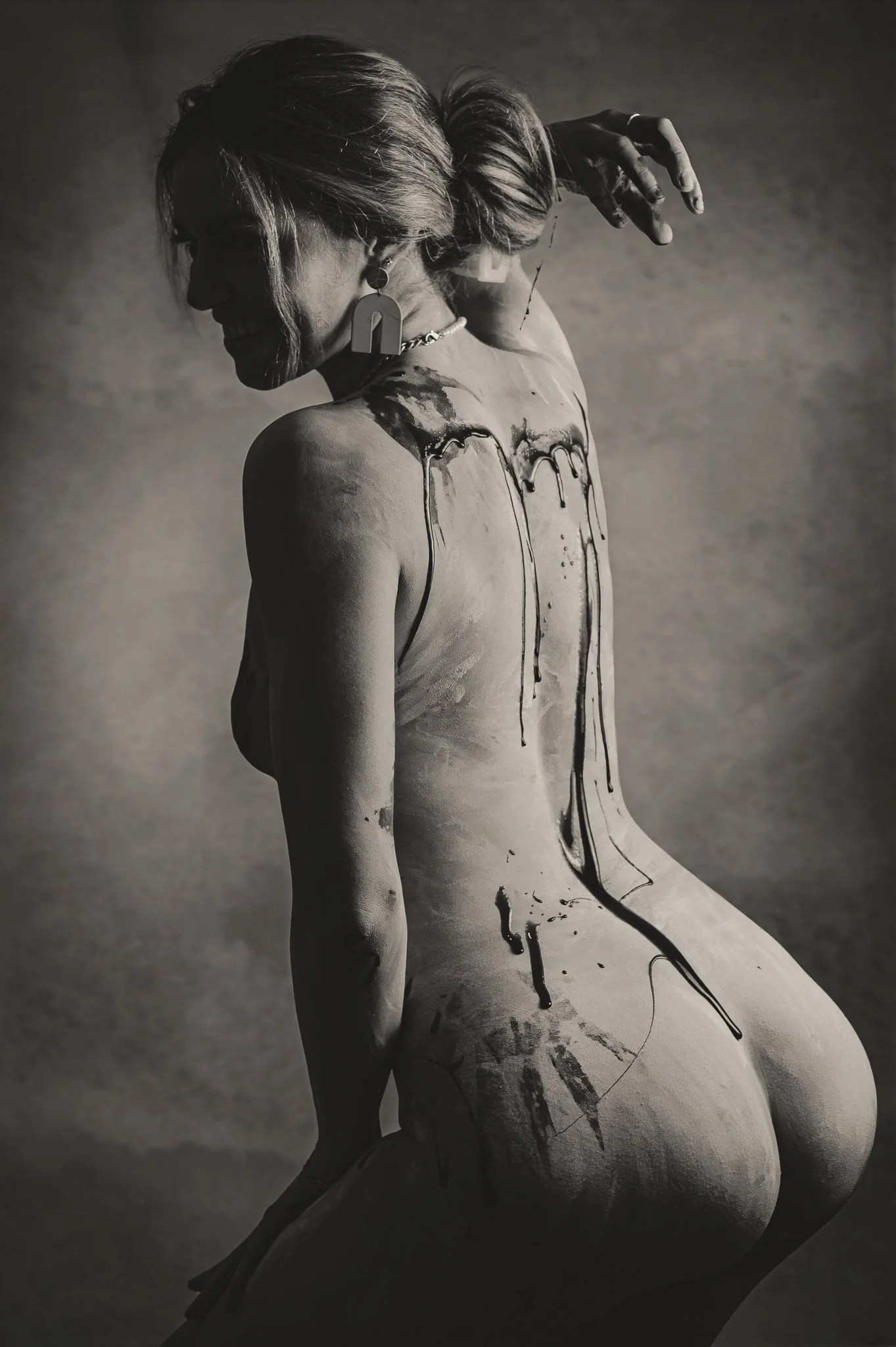 woman pouring melted chocolate down her spine