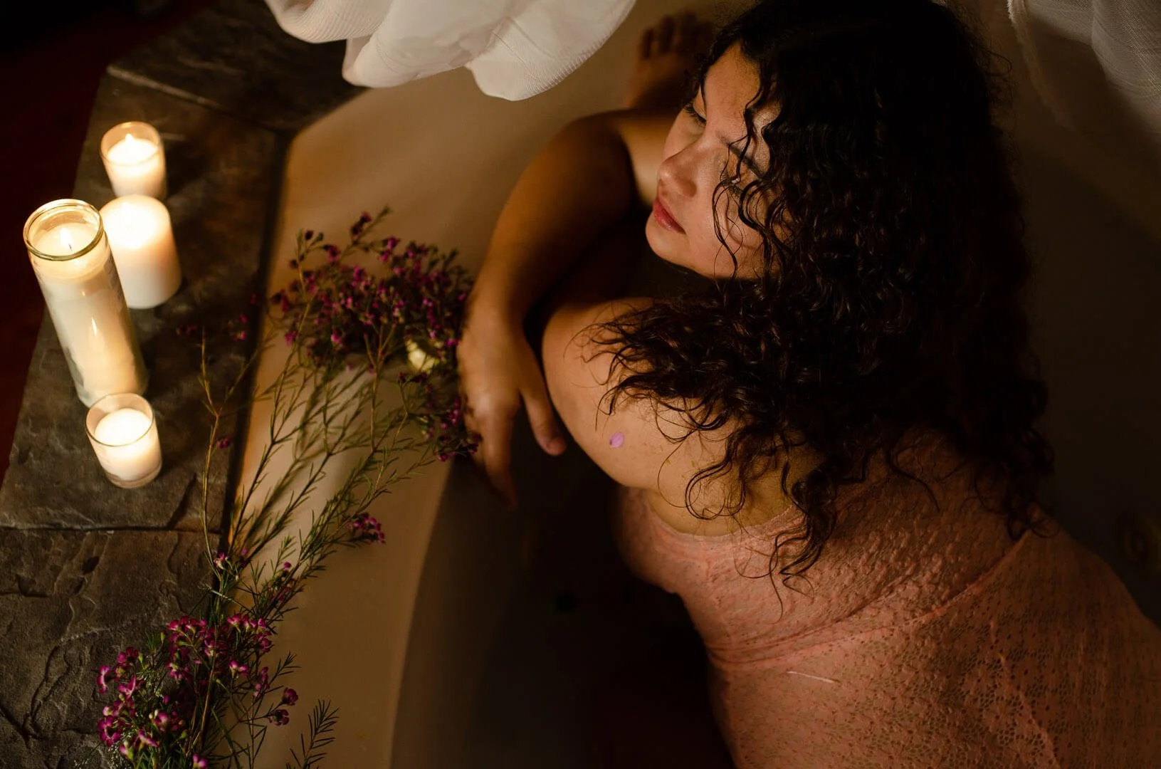 woman in bath tub with candles