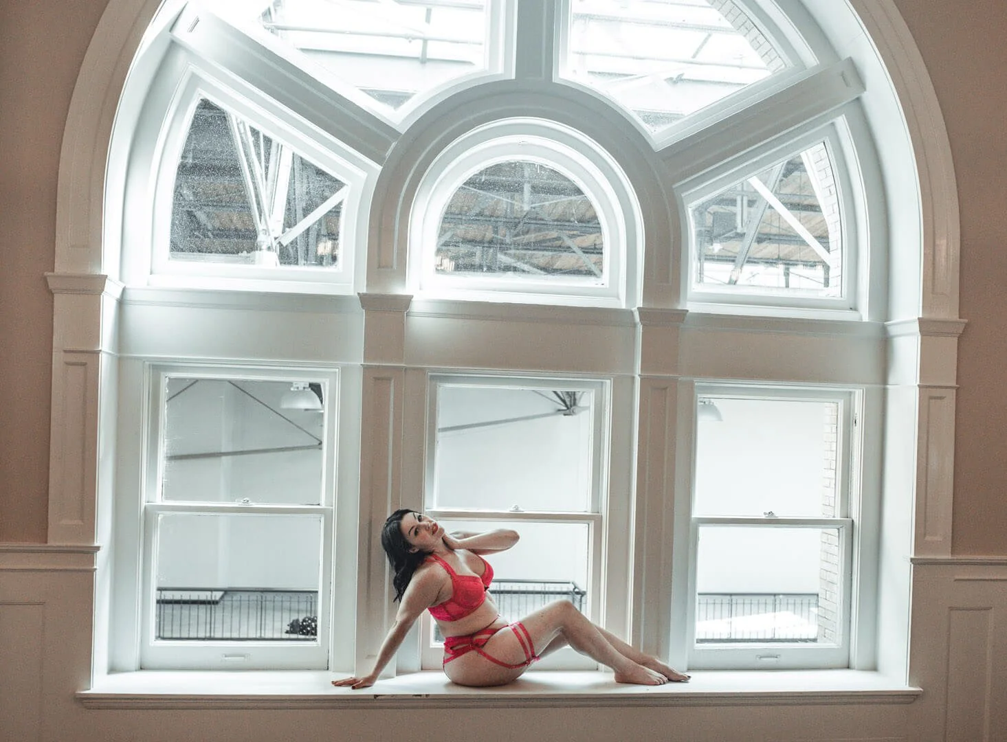 woman in very large window wearing lingerie