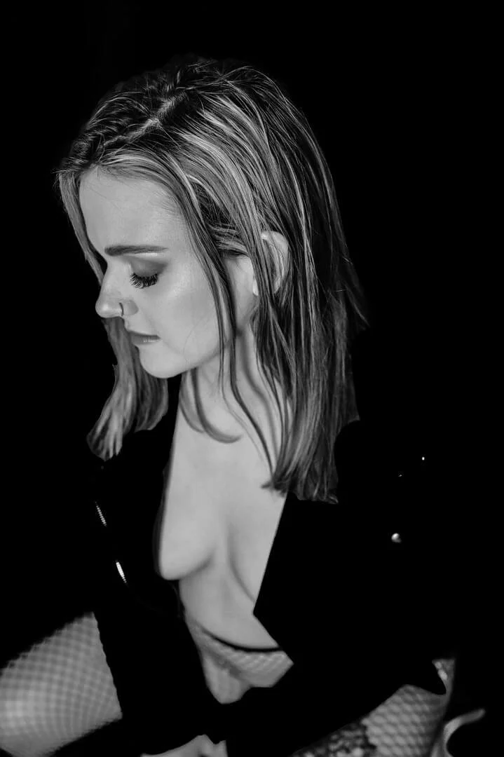 woman in leather jacket and no bra