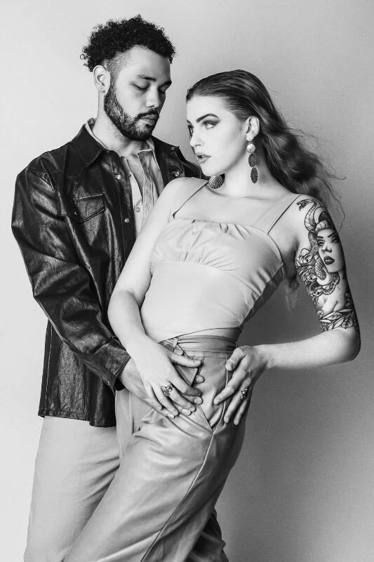 young woman and man standing against wall