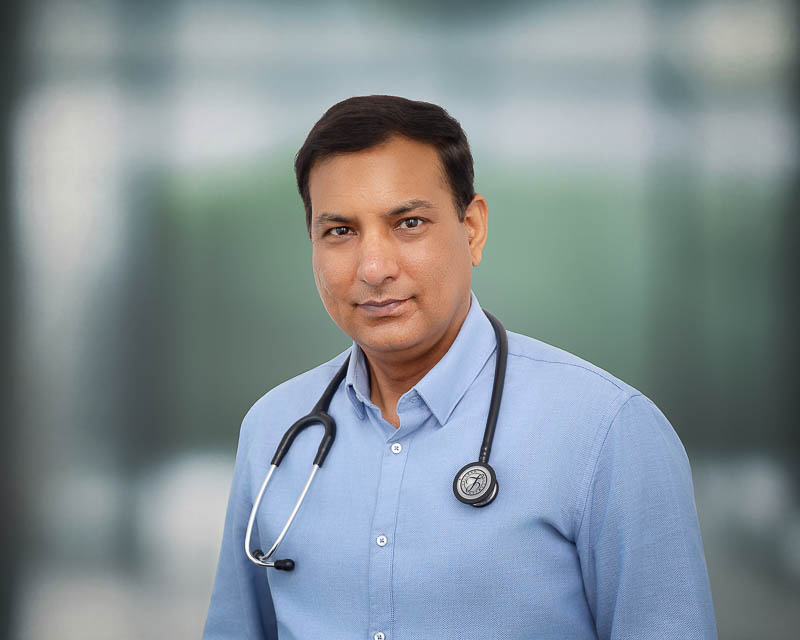 Professional headshot of a medical practitioner in a clinical setting