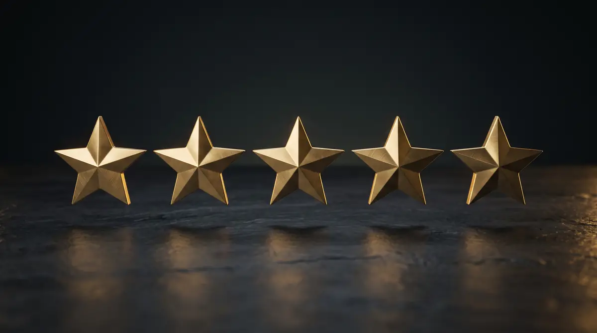 Five polished brass five-pointed stars in a row on dark slate