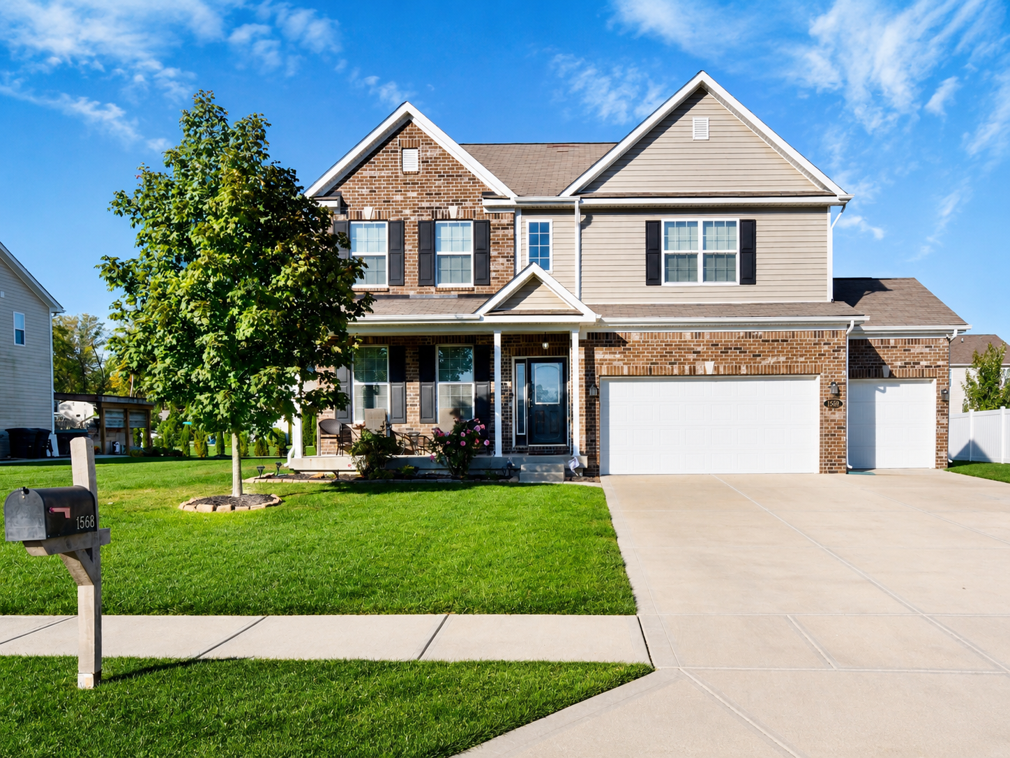 Two-story suburban home with green lawn and bright summer sky, showing strong curb appeal for a home sale.