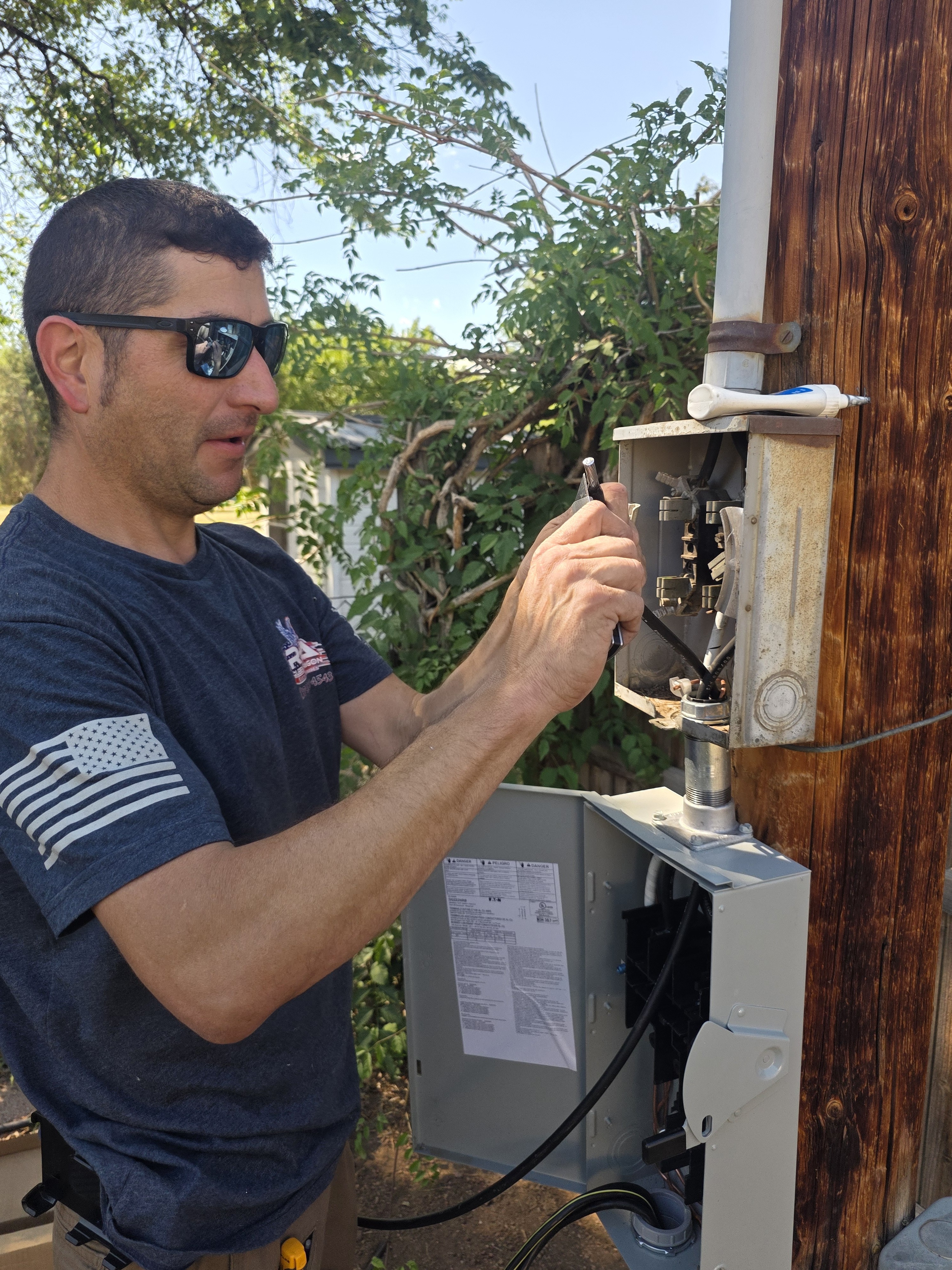 Licensed master electrician Ruben Aragon working on electrical service near Brighton, CO