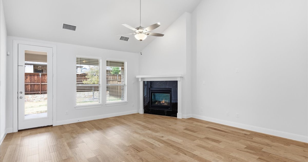 Light-filled living room with oak floors and gas fireplace in a Northlake, Texas home Light-filled living room with oak floors and gas fireplace in a Northlake, Texas home