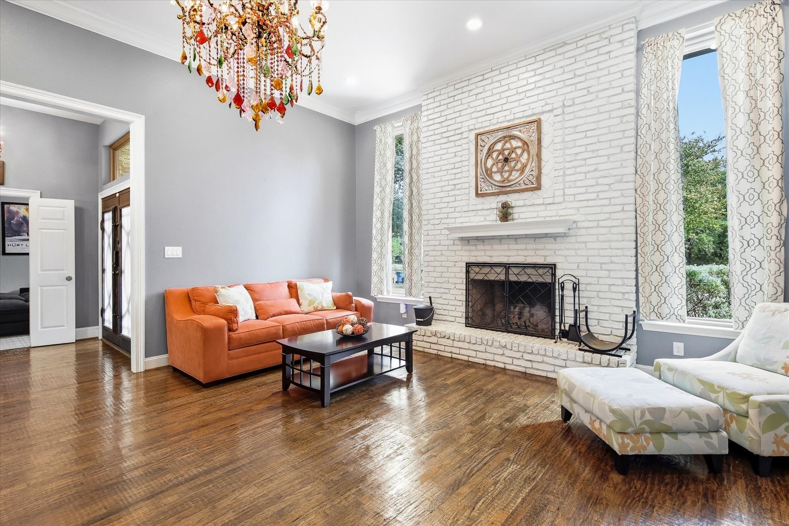 Living room with hand-scraped wood floors and wood-burning fireplace in Flower Mound home