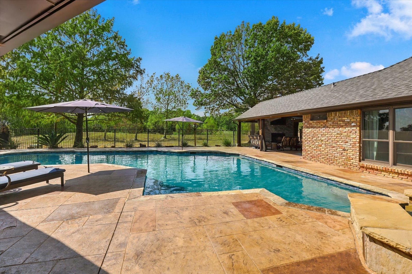 Backyard pool and covered outdoor living areas behind the Flower Mound home