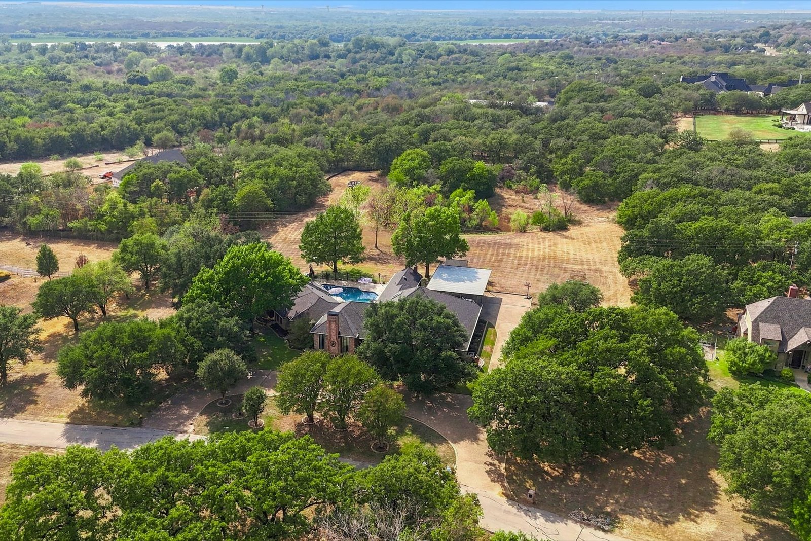 Aerial view of 3801 Post Oak Road showing the home, swimming pool, pond, and two-acre lot