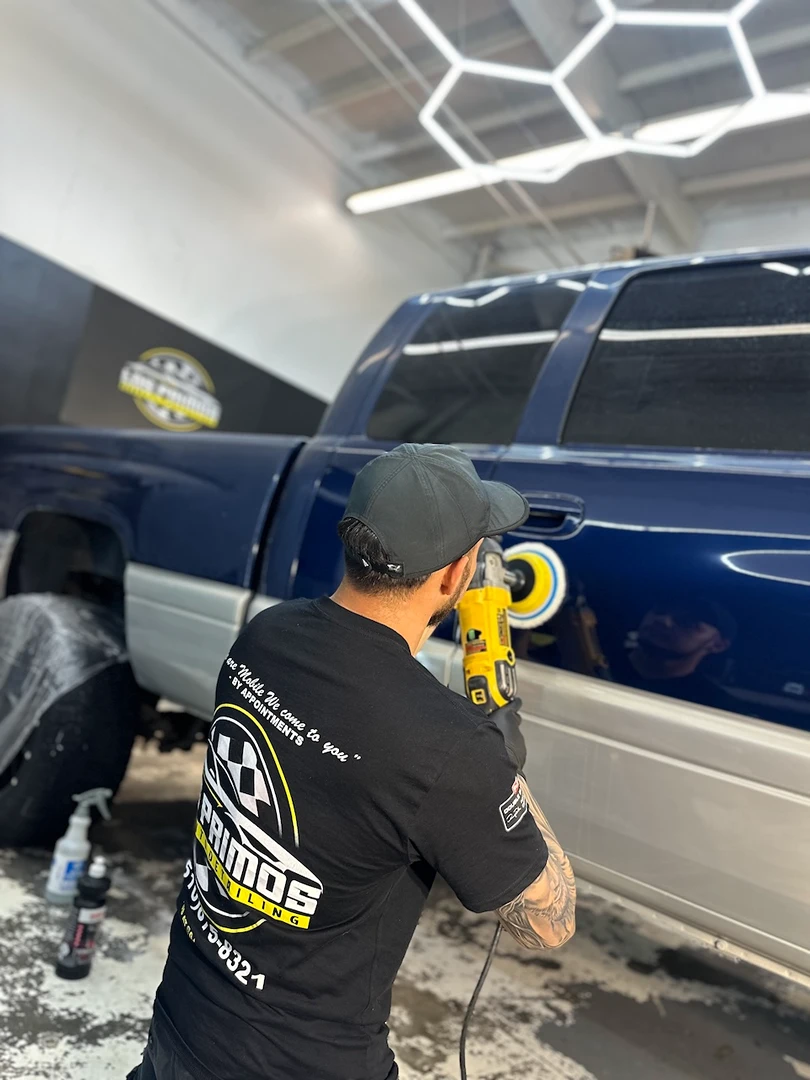 Joaquin inside Los Primos Auto Detailing polishing a regular maintenance truck customer inside the detailing shot