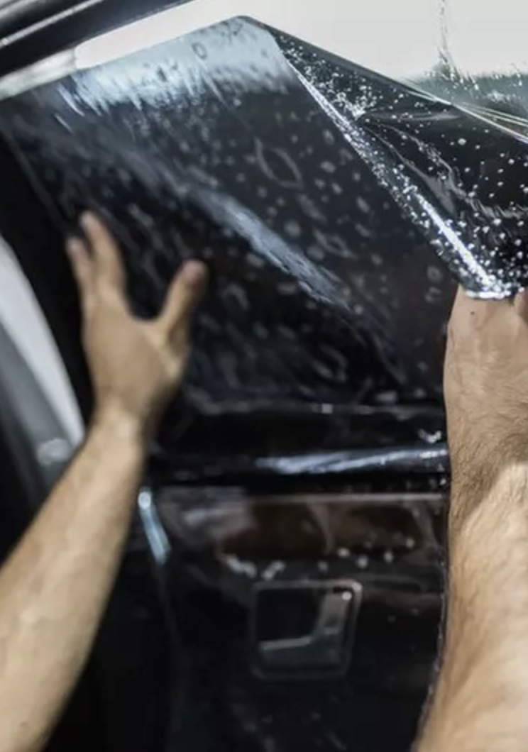 Window tints on car with rain drops