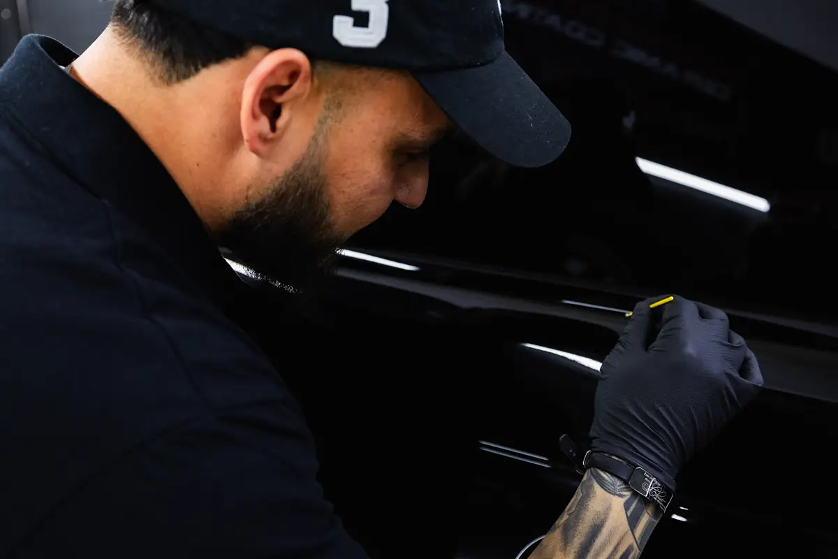 Joaquin inside Los Primos Auto Detailing polishing a regular maintenance truck customer inside the detailing shot