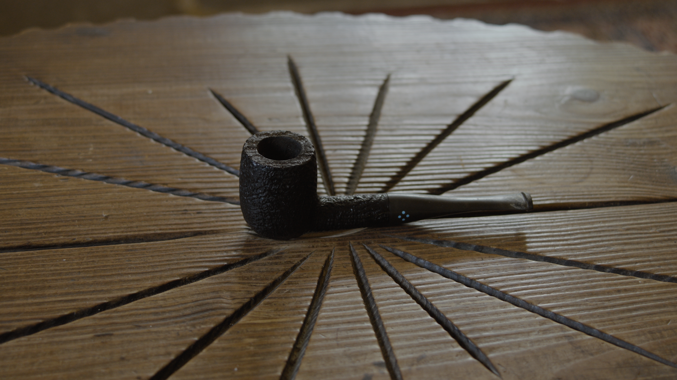 Tobacco pipe resting on carved wood