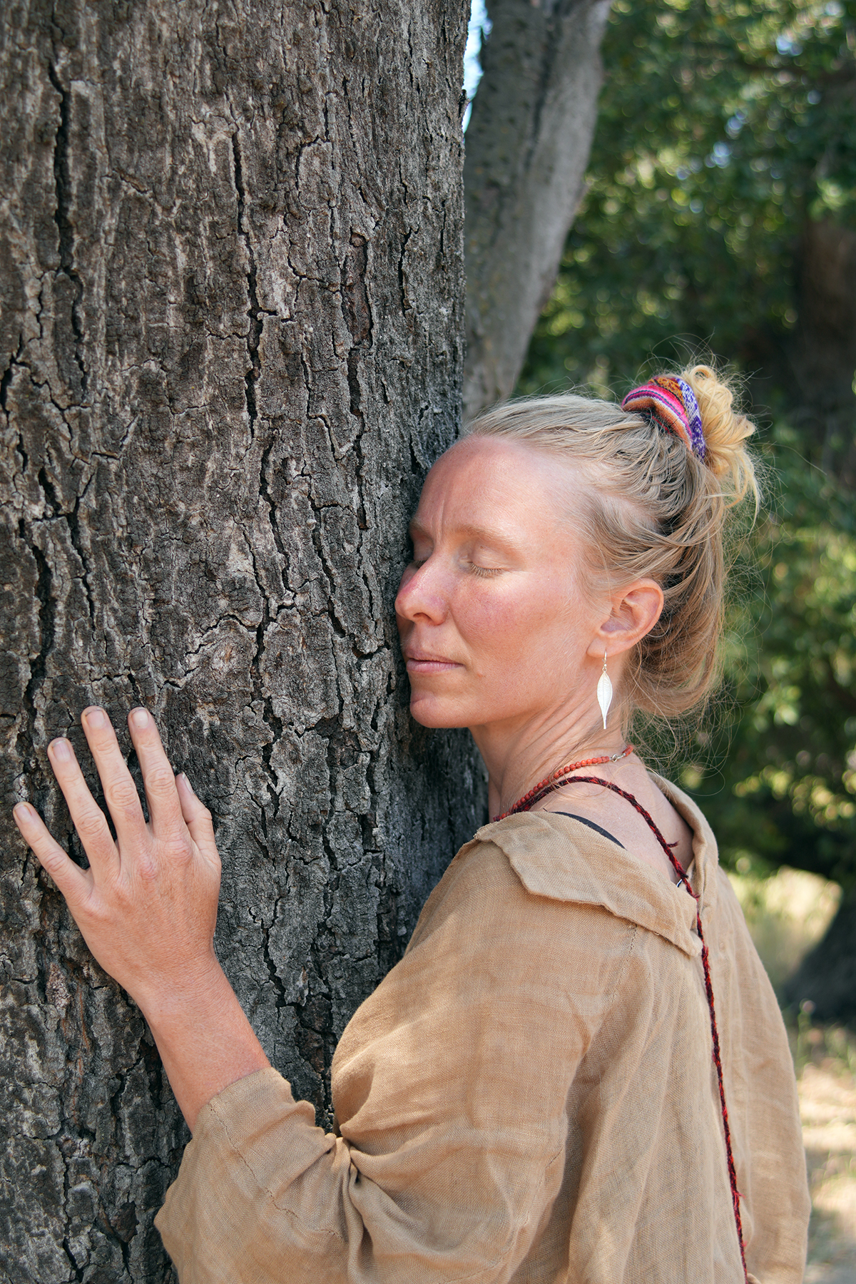 A woman resting against a tree during a Master Tree Diet