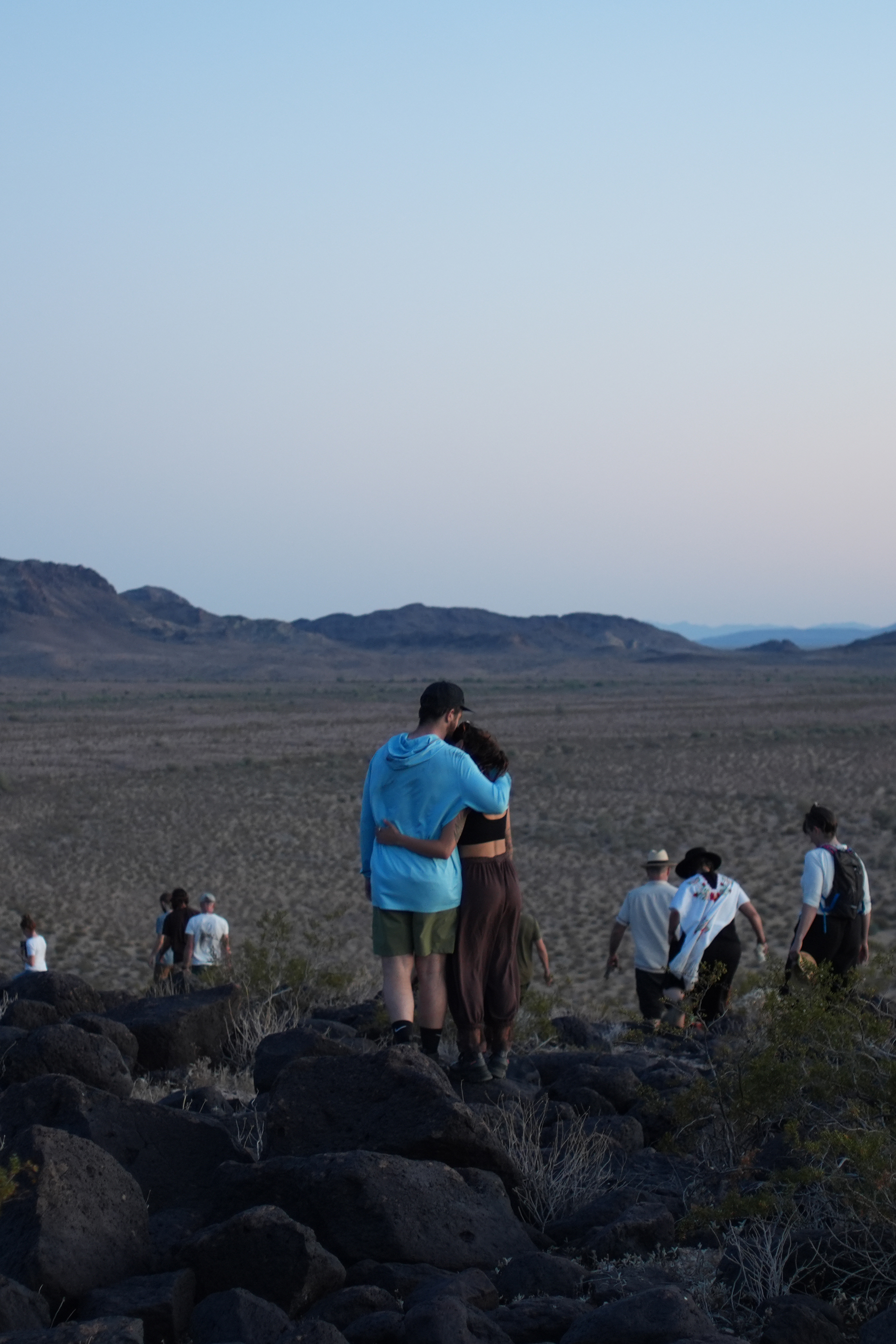 Participants overlooking the desert, with two people embracing