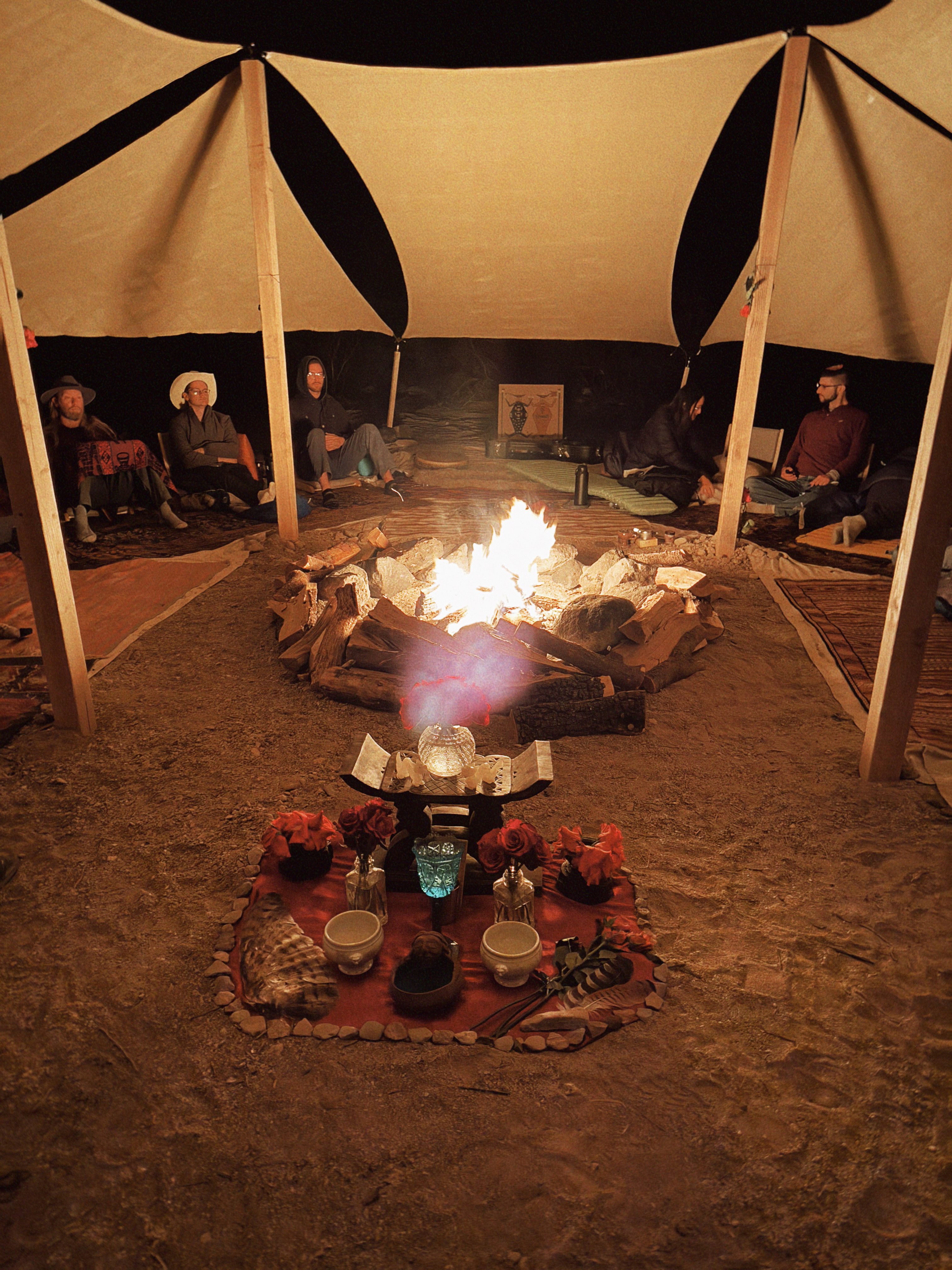 Ceremony circle around a fire with a Rose altar in the foreground