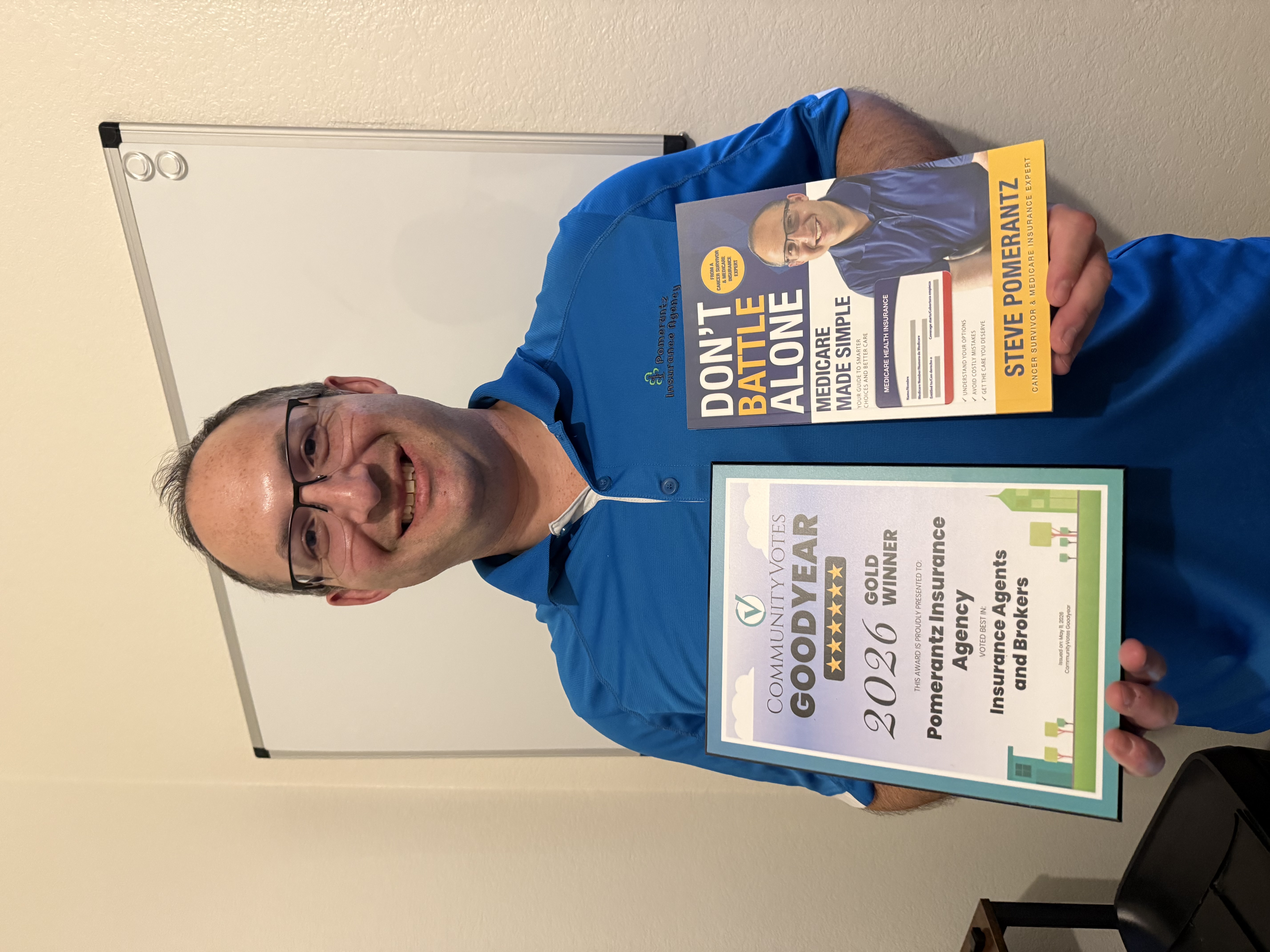 Steve Pomerantz holding award and Medicare book