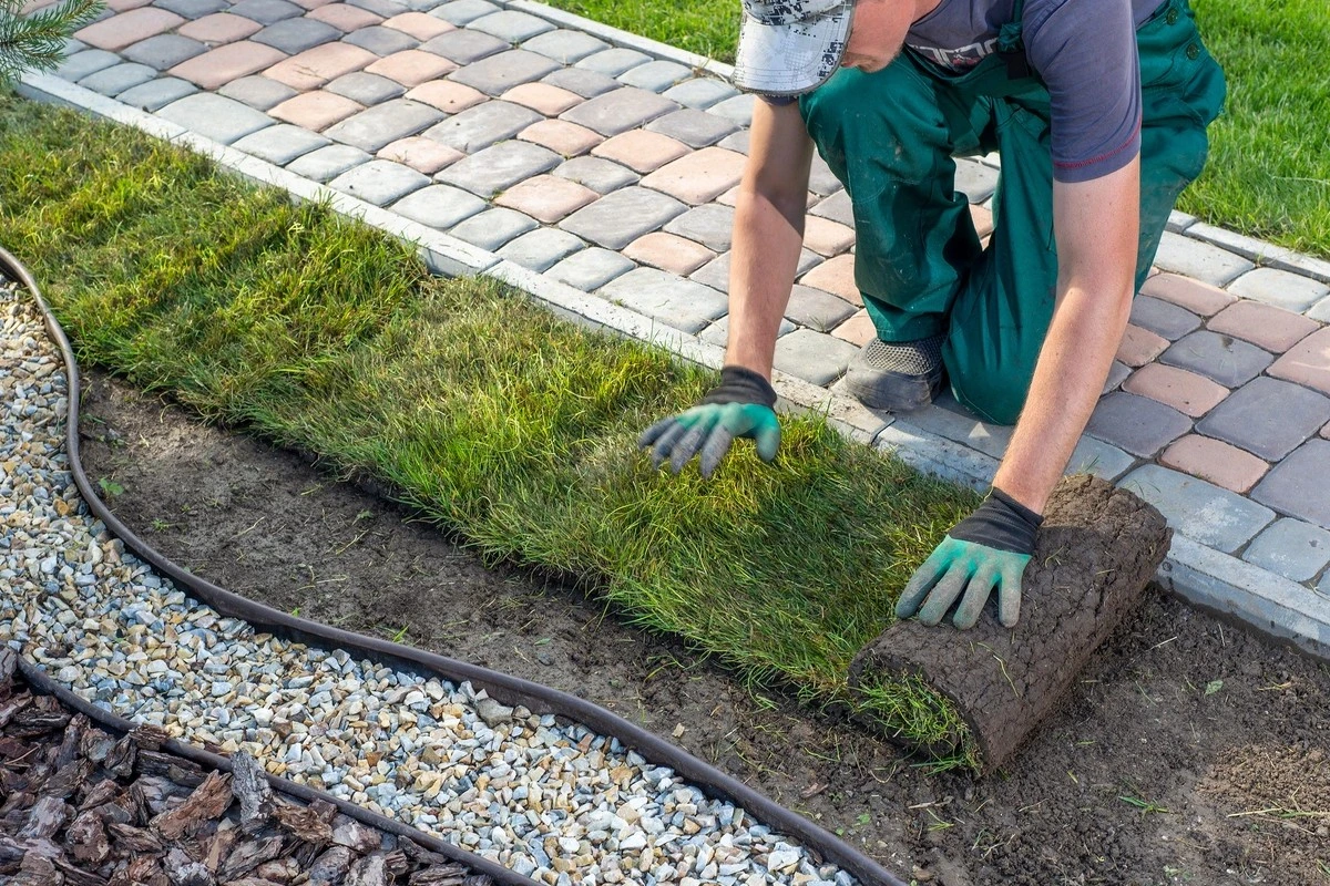 A person installing landscape
