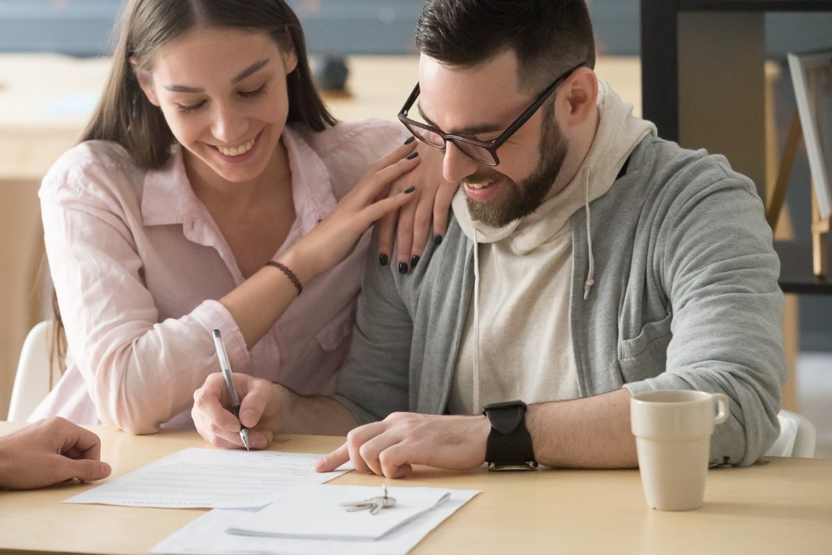A couple signing documents at their kitchen counter during a mobile notary appointment