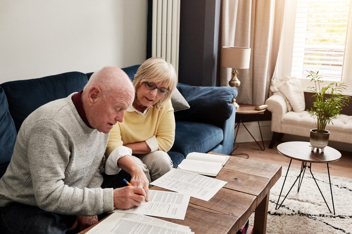 A professional signing loan documents at a desk with a notary present