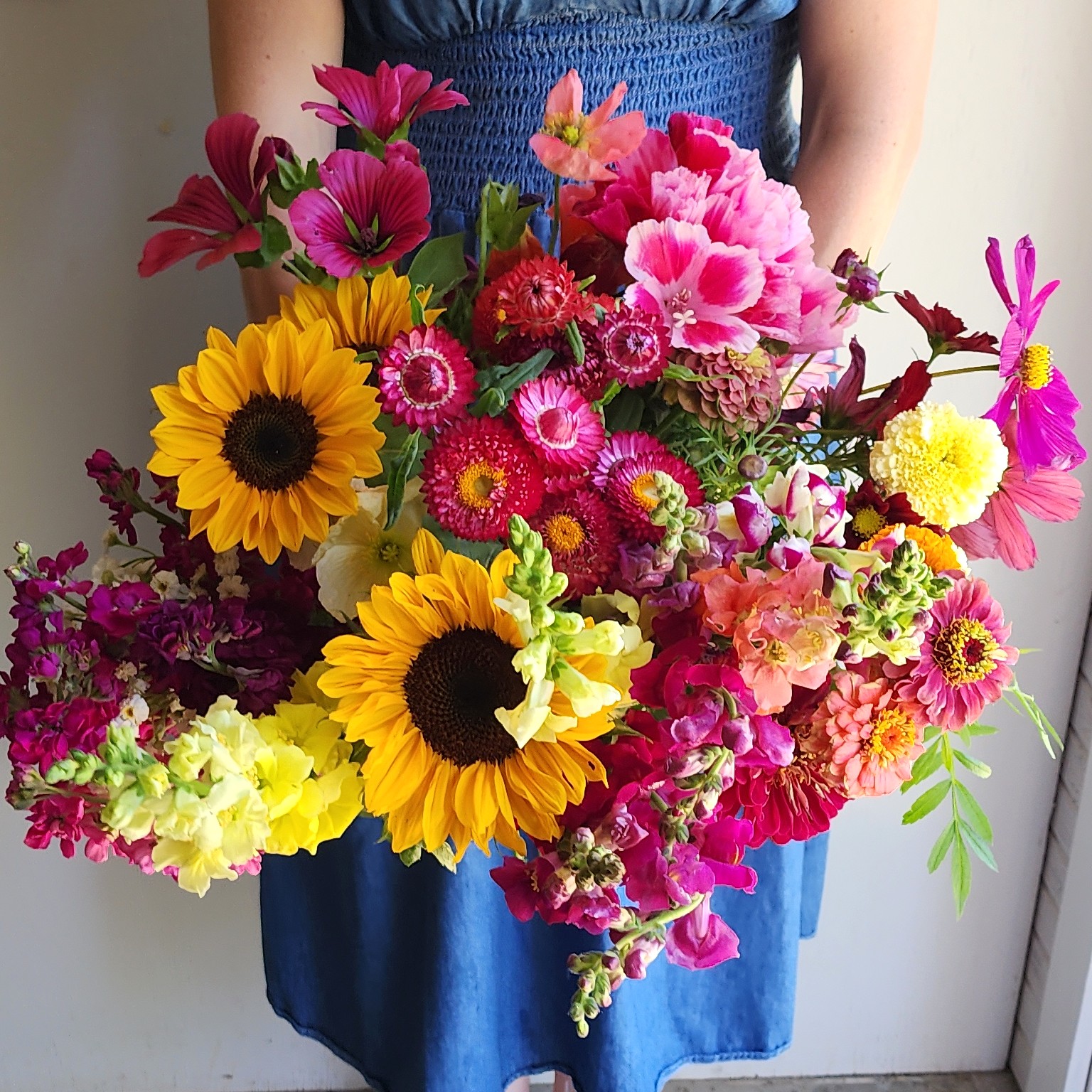 Paula holding a bright colorful bundle of flowers