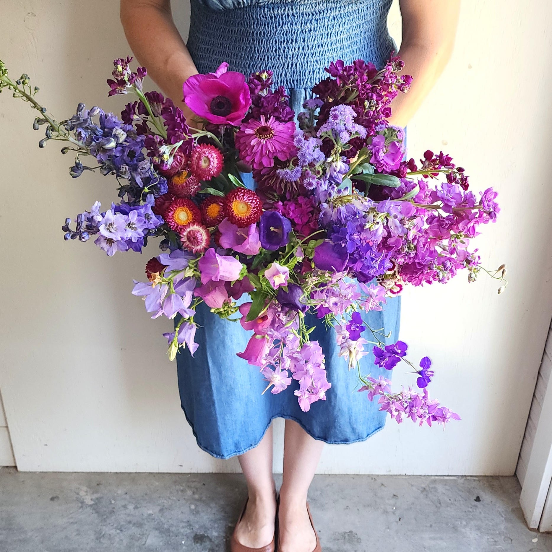 Paula holding a bundle of purple flowers