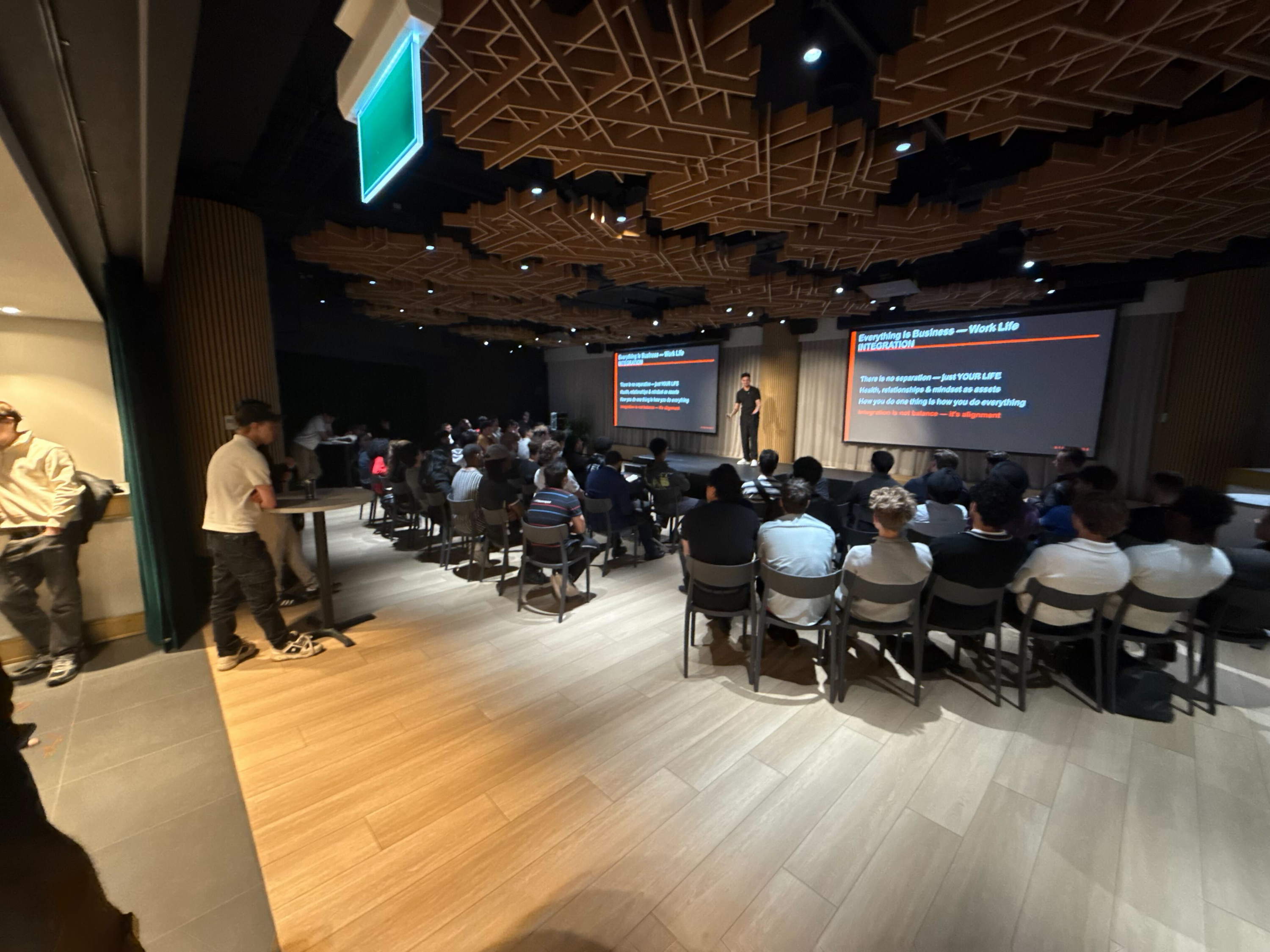 The Sales Revolution live event — full seated audience, speaker on stage, screens and venue visible during the presentation
